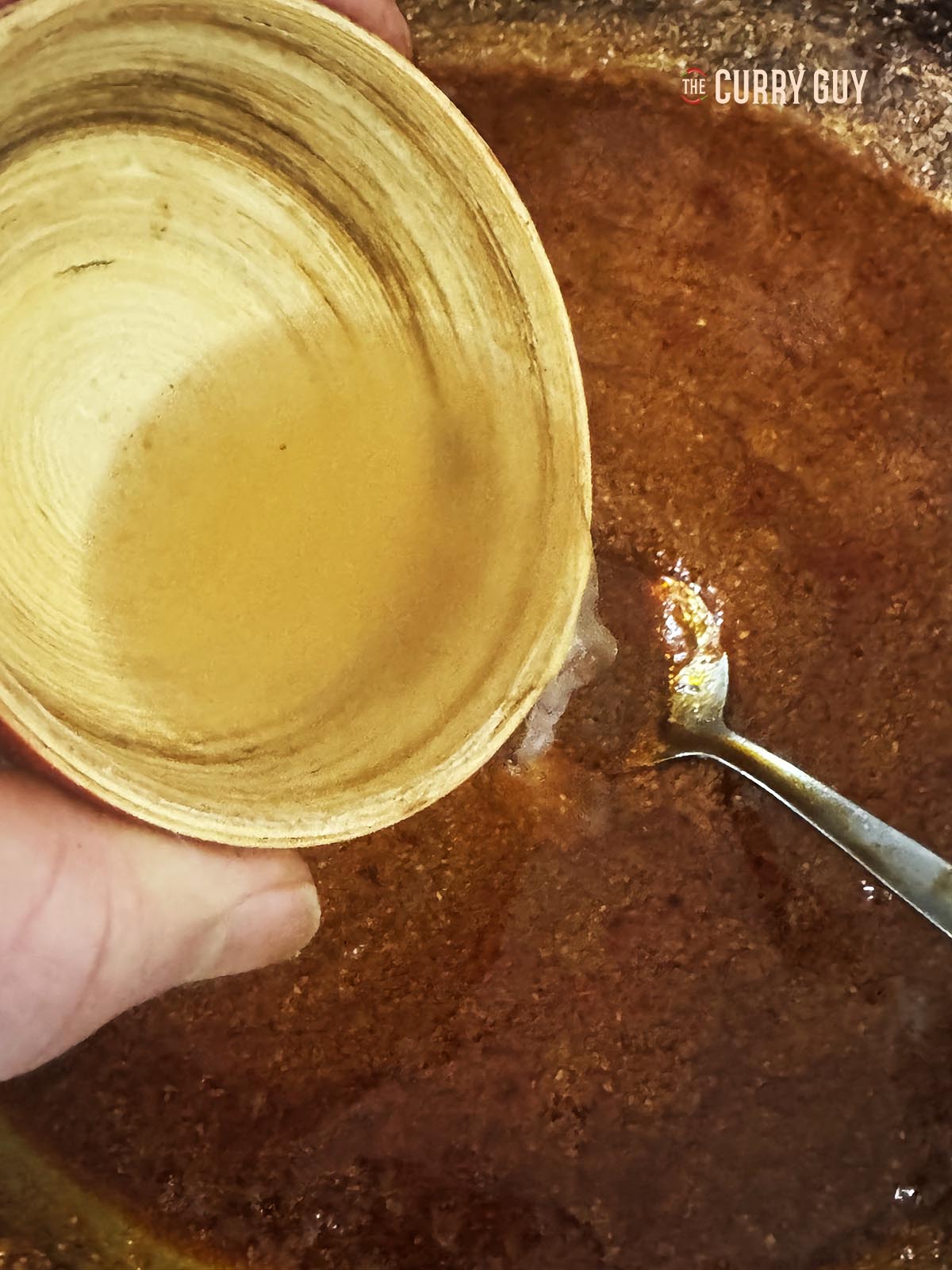 Adding the vinegar to the curry paste.