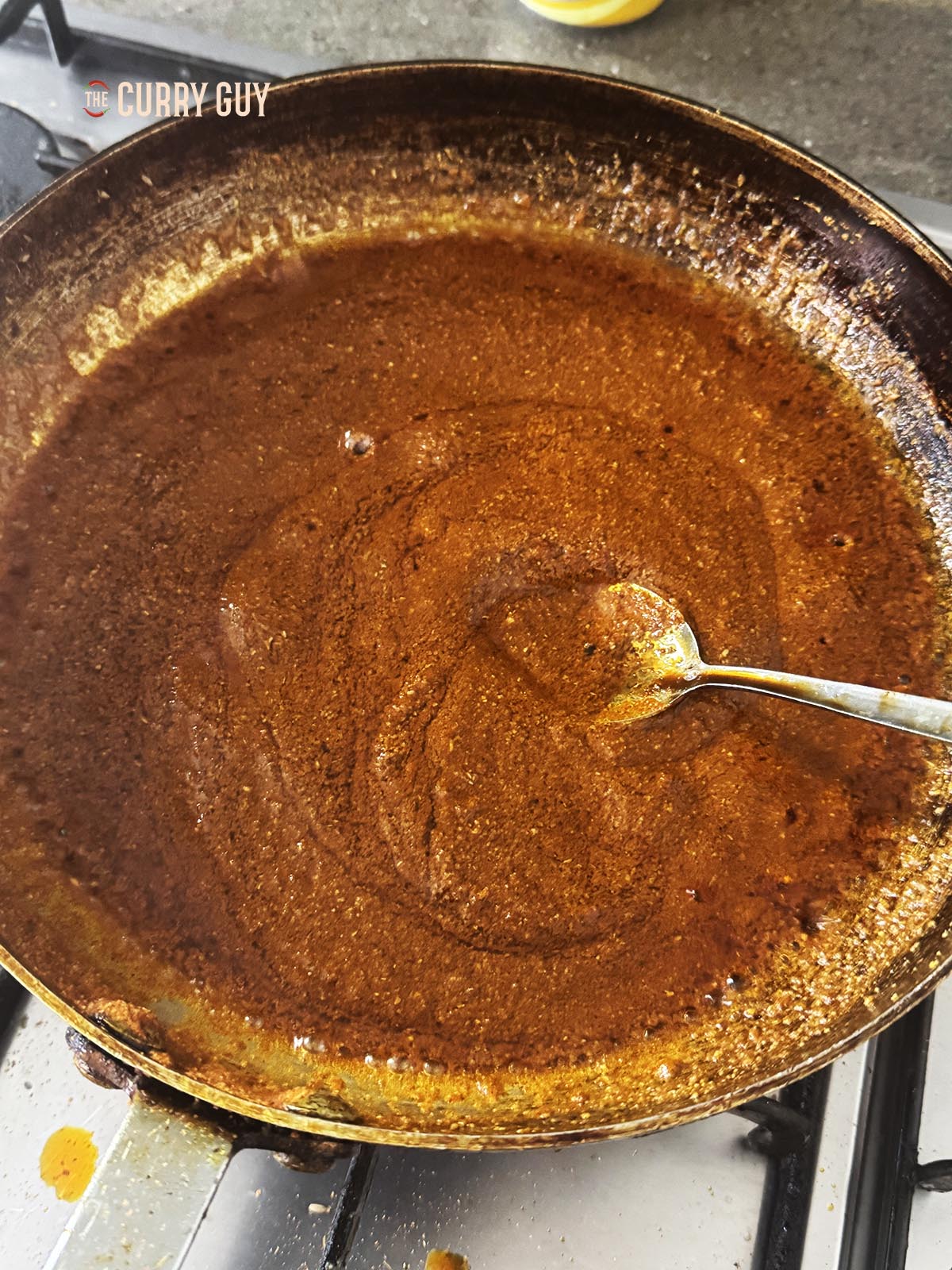 Stirring in the oil and heating it with the paste ingredients. 