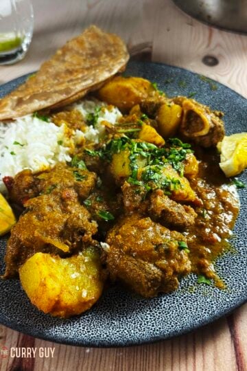 Slow cooker railway lamb curry on a serving plate with rice and chapati.