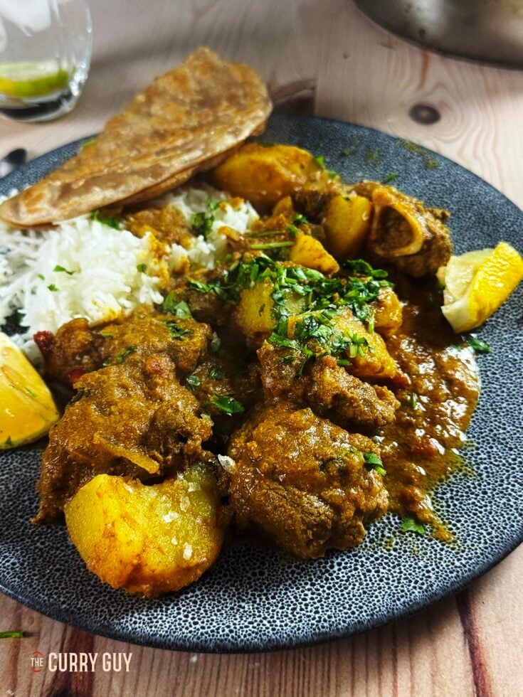 Slow cooker railway lamb curry on a serving plate with rice and chapati.