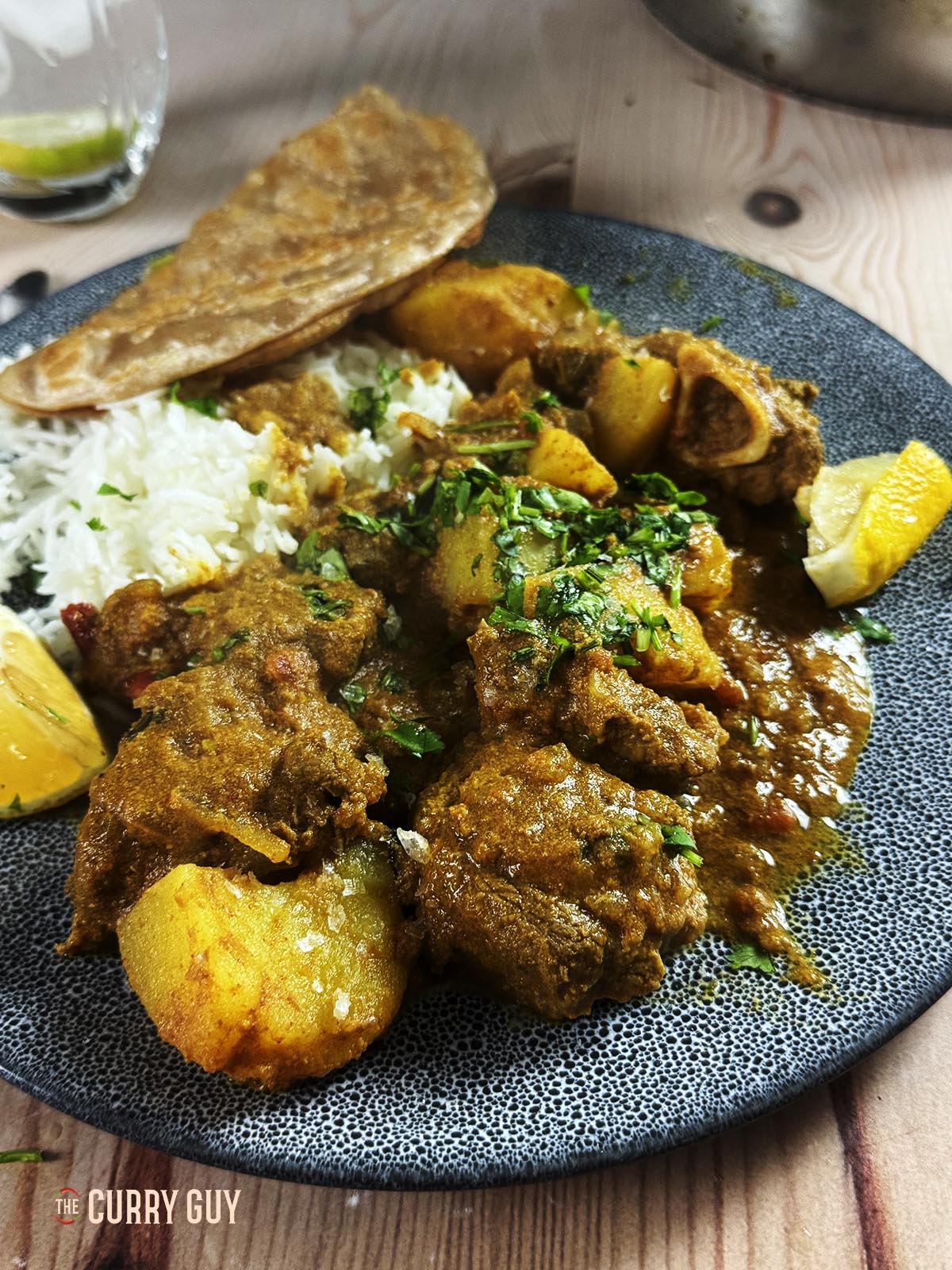 Slow cooker railway lamb curry on a serving plate with rice and chapati.
