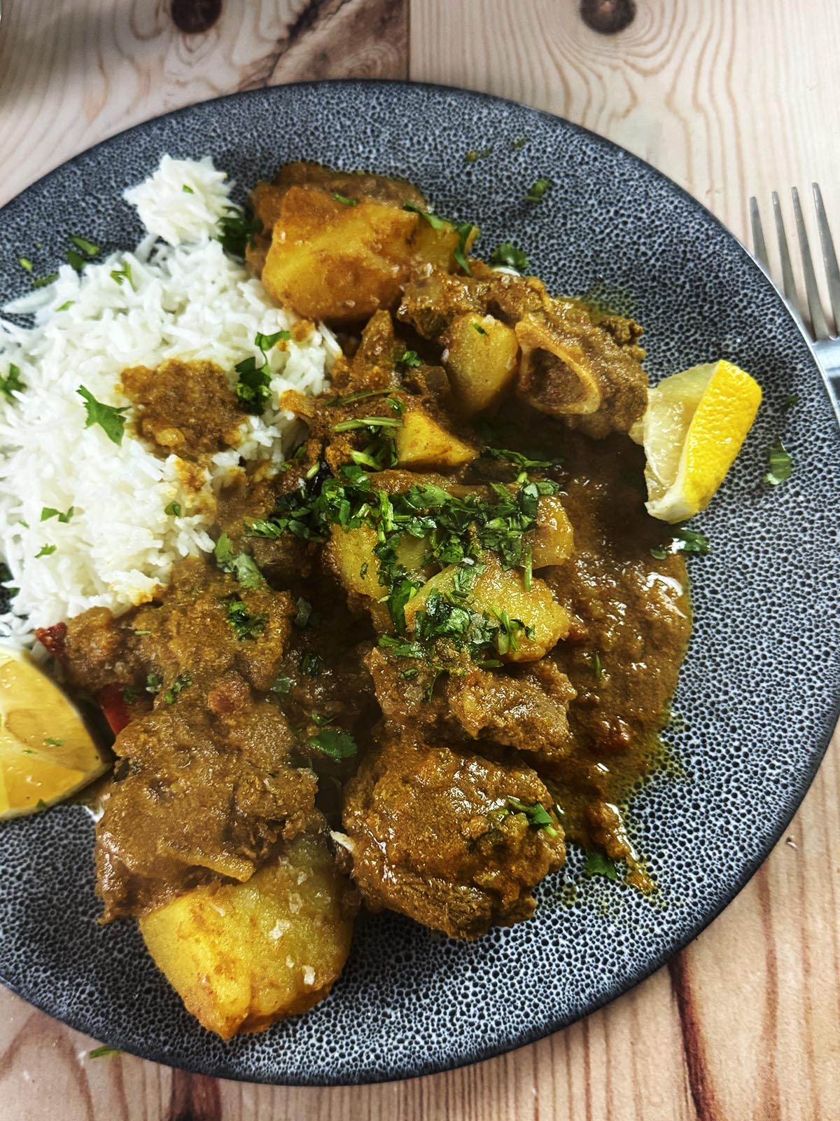 Slow cooker railway lamb curry on a serving plate with rice.