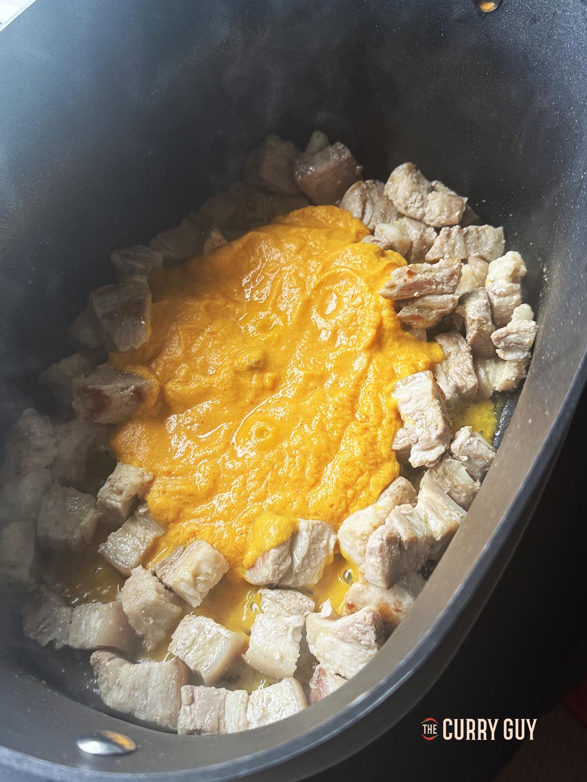 Adding the blended paste to the pork to simmer for 3 minutes.