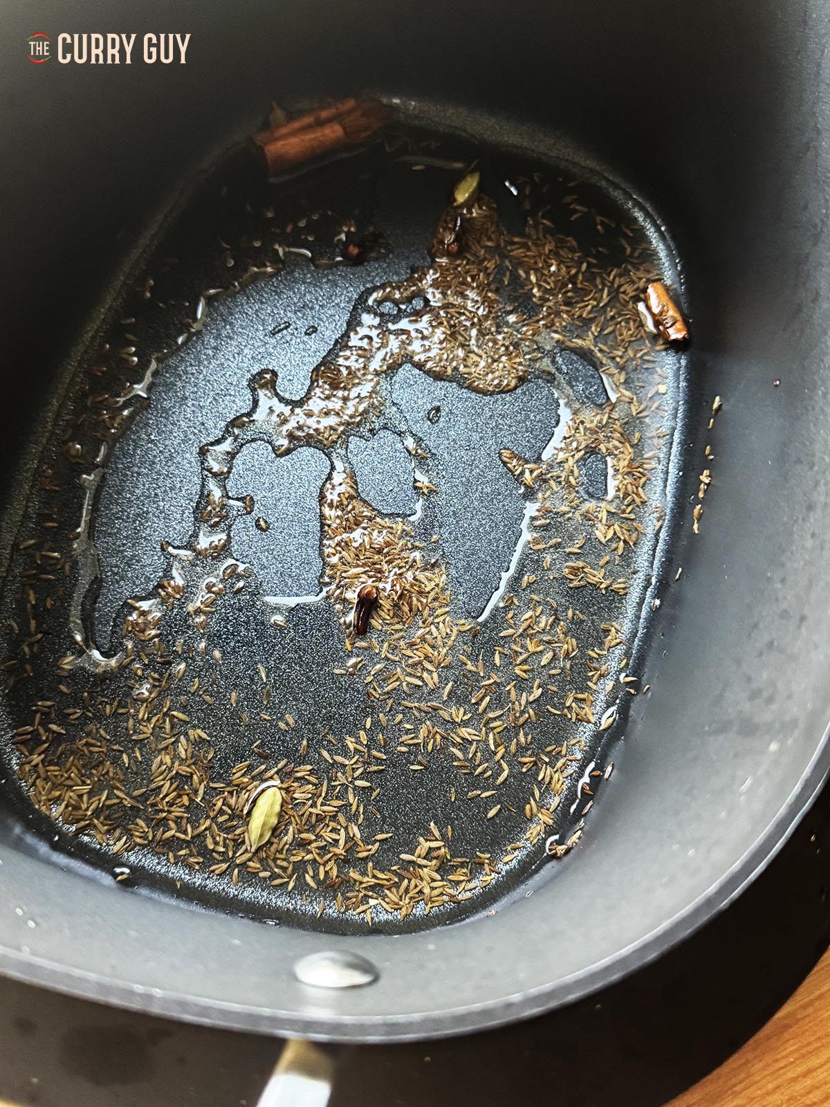Infusing the whole spices into the oil in a slow cooker using the sauté mode.