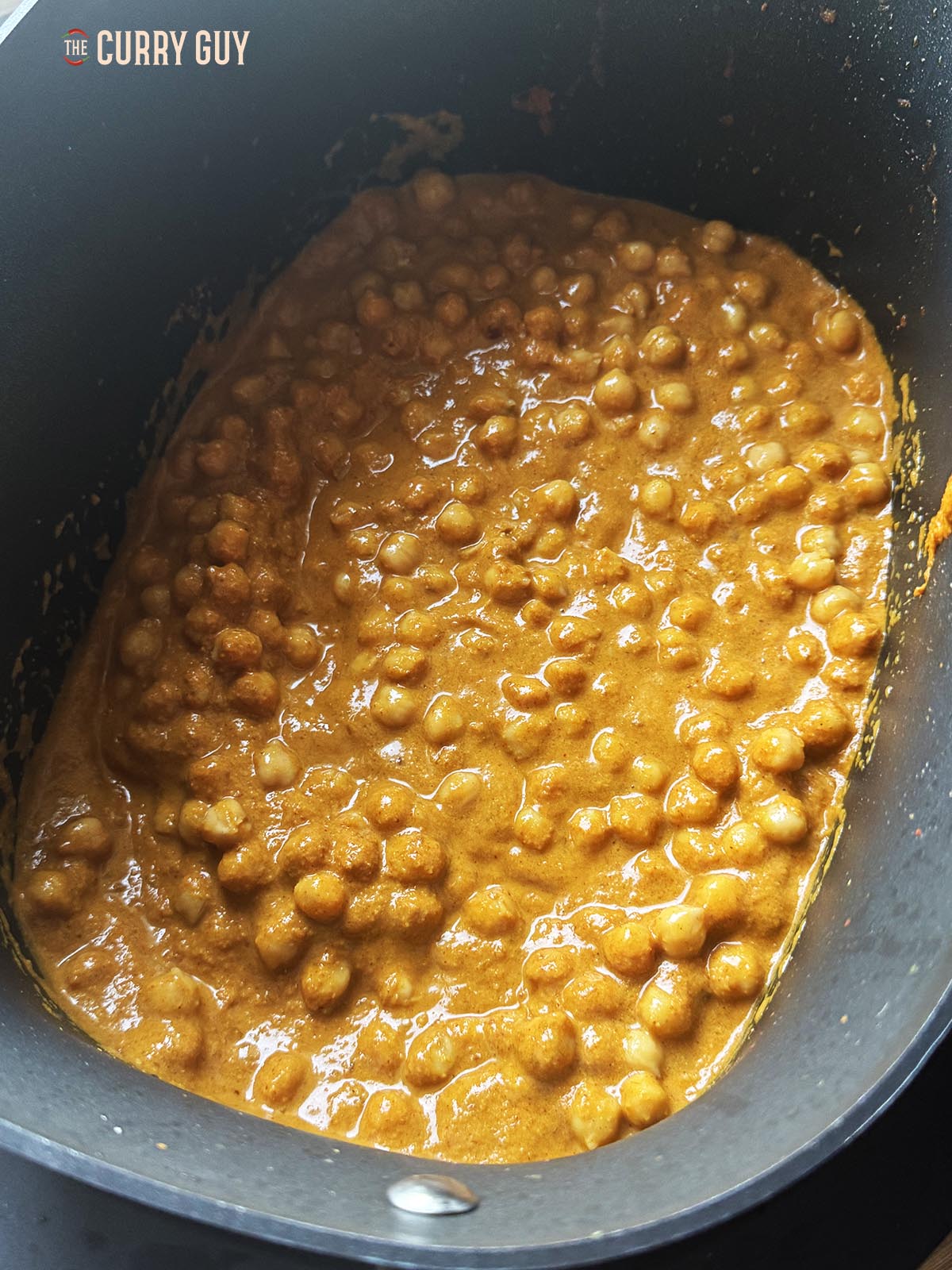Stirring the chickpeas into the sauce. 