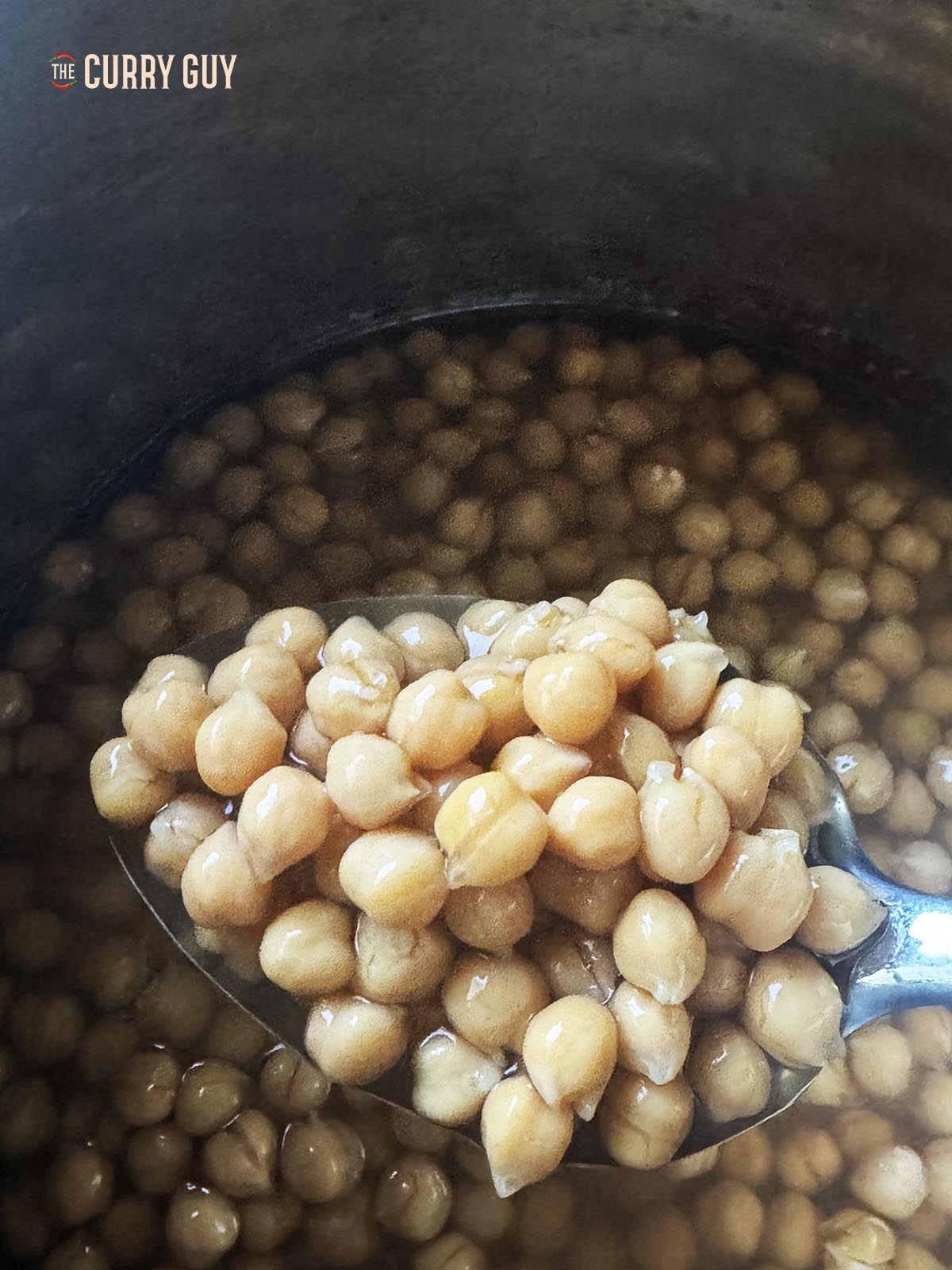 A spoonful of chickpeas cooked to perfection in a slow cooker.
