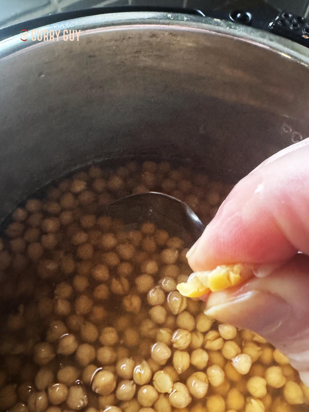 Smashing a chickpea between two fingers.