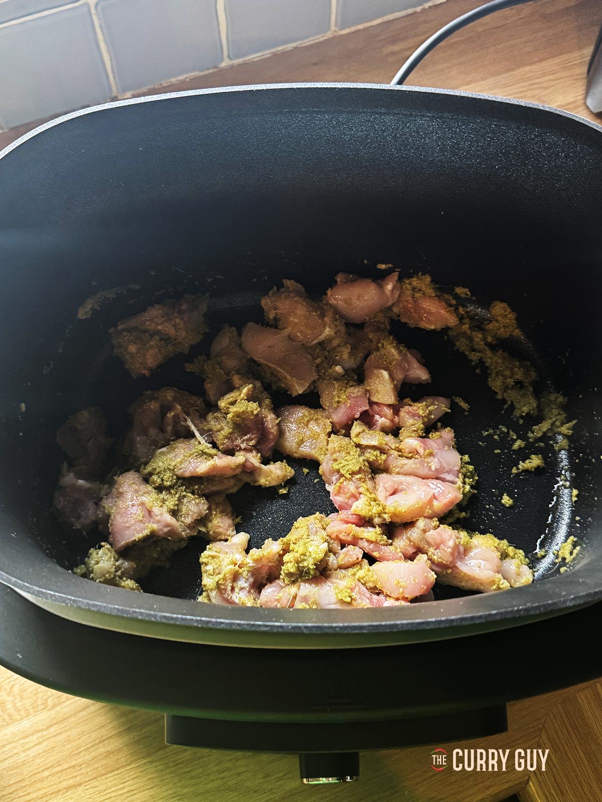 Adding the chicken to cook in the pan.