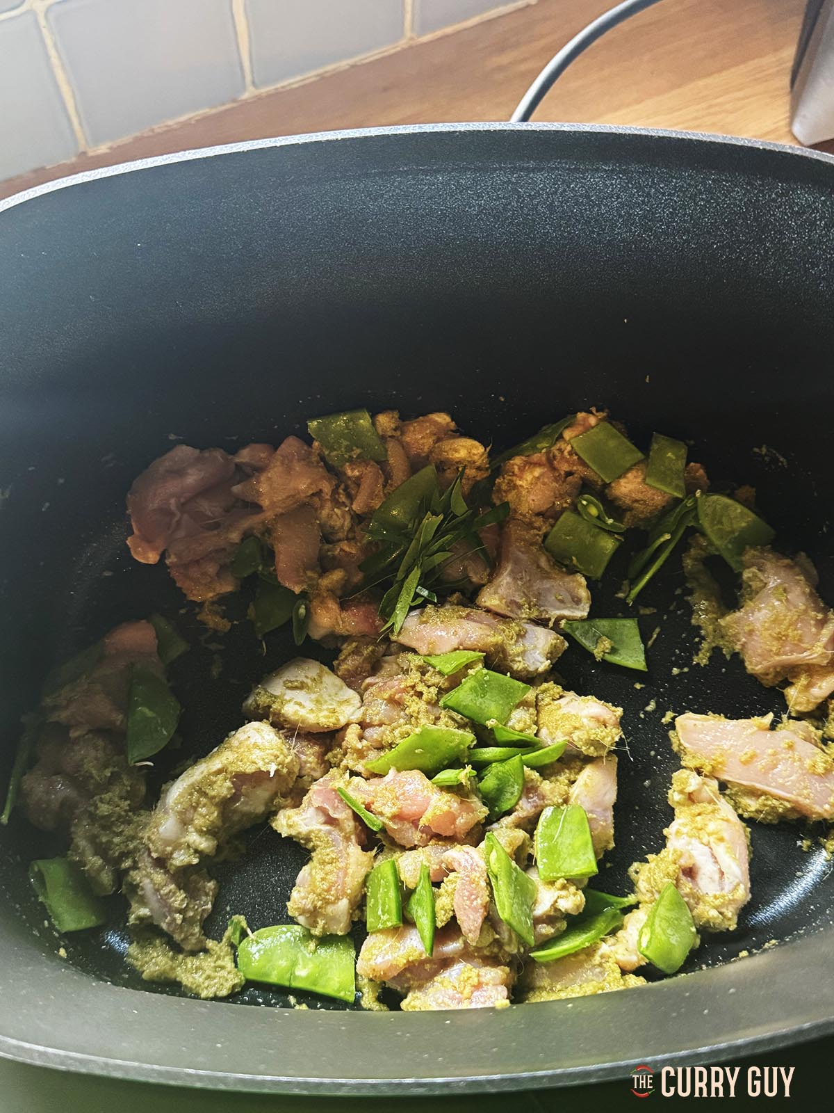 Adding mange tout to the pan.