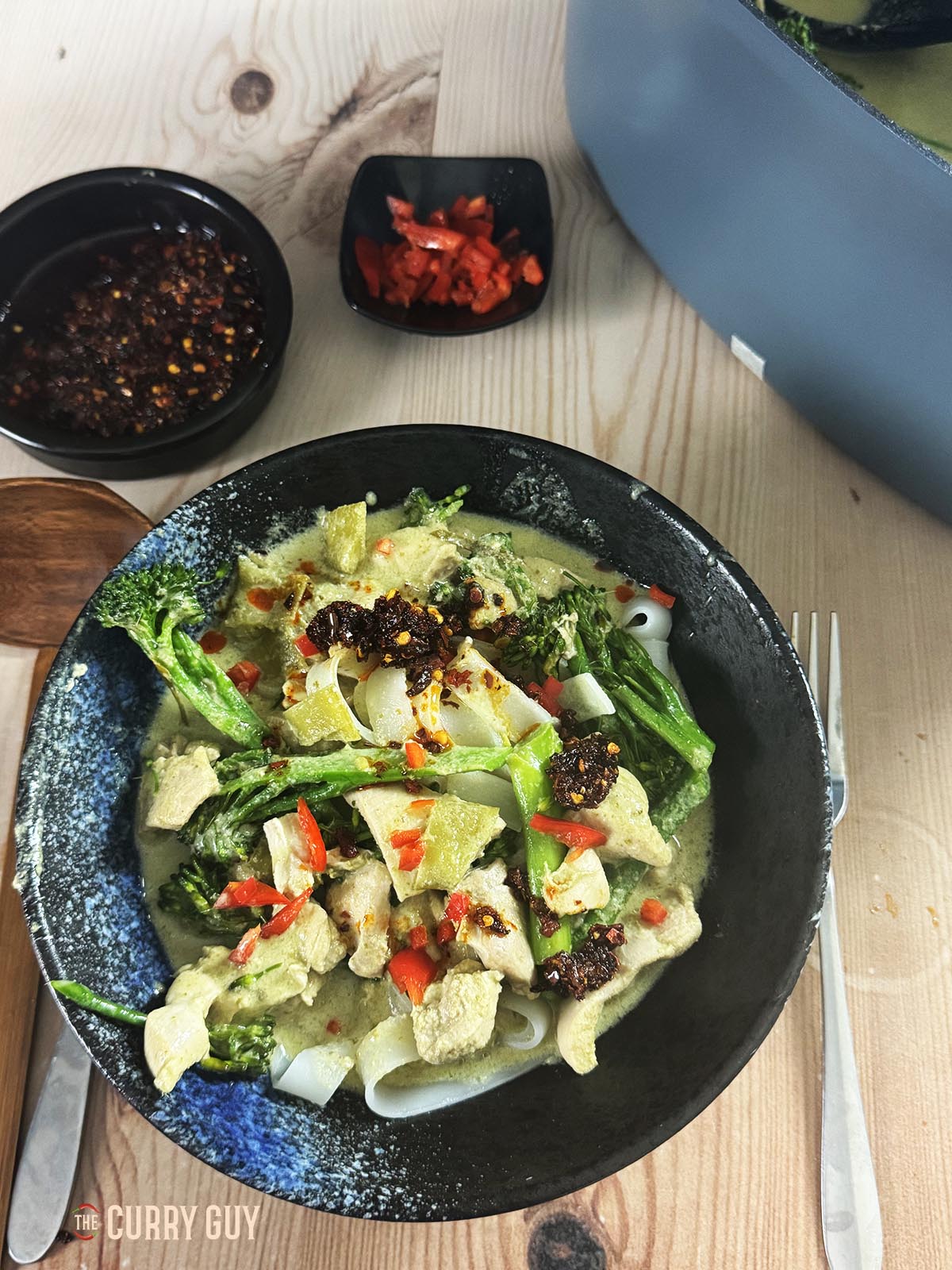 The slow cooker Thai green curry in a serving bowl with rice noodles.