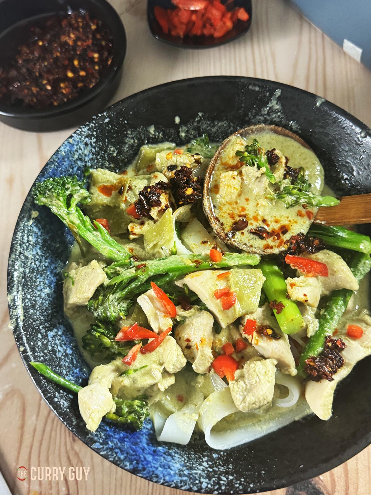 Slow cooker Thai green curry in a bowl with rice noodles.