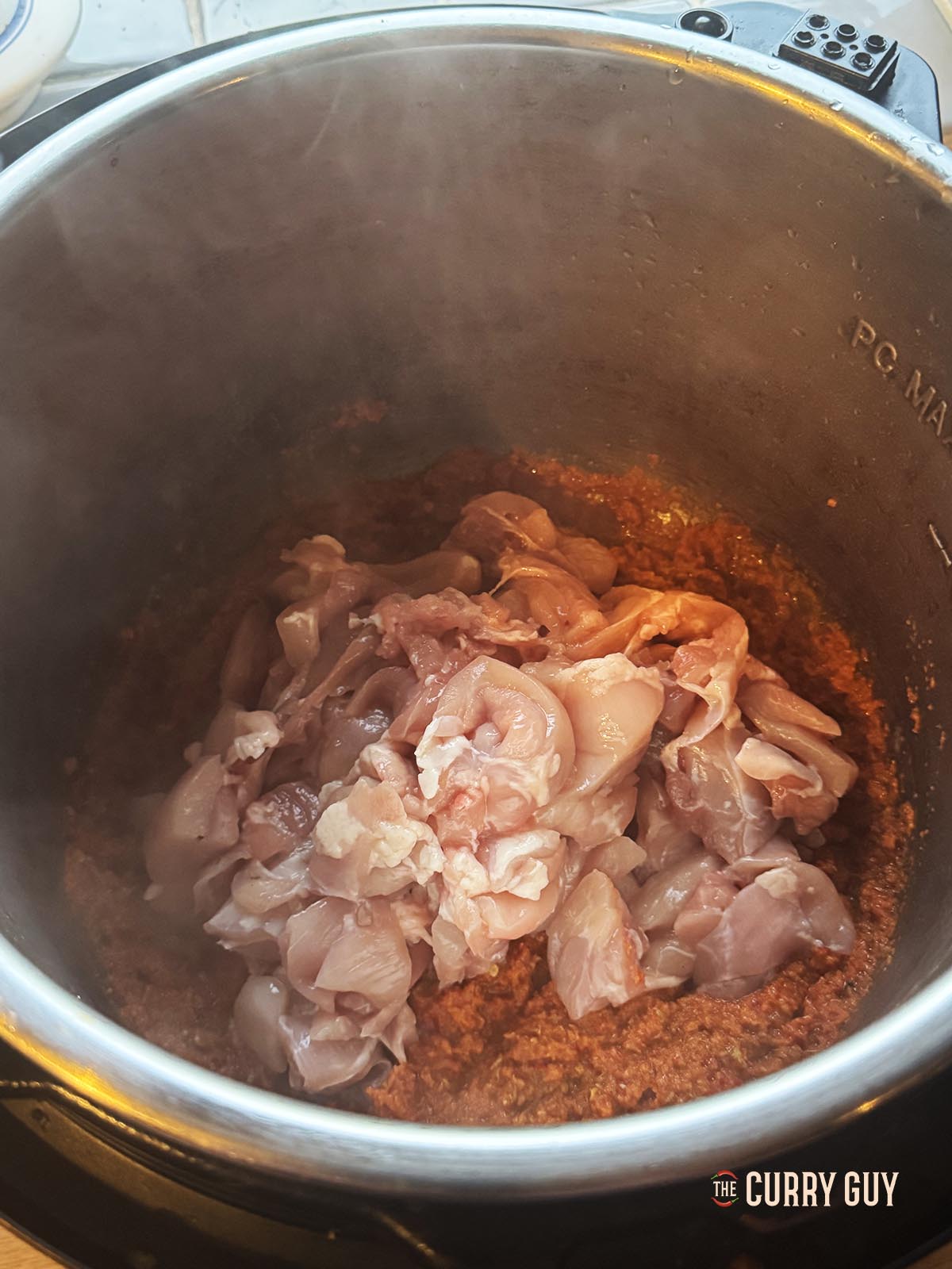Stirring the chicken into the paste.