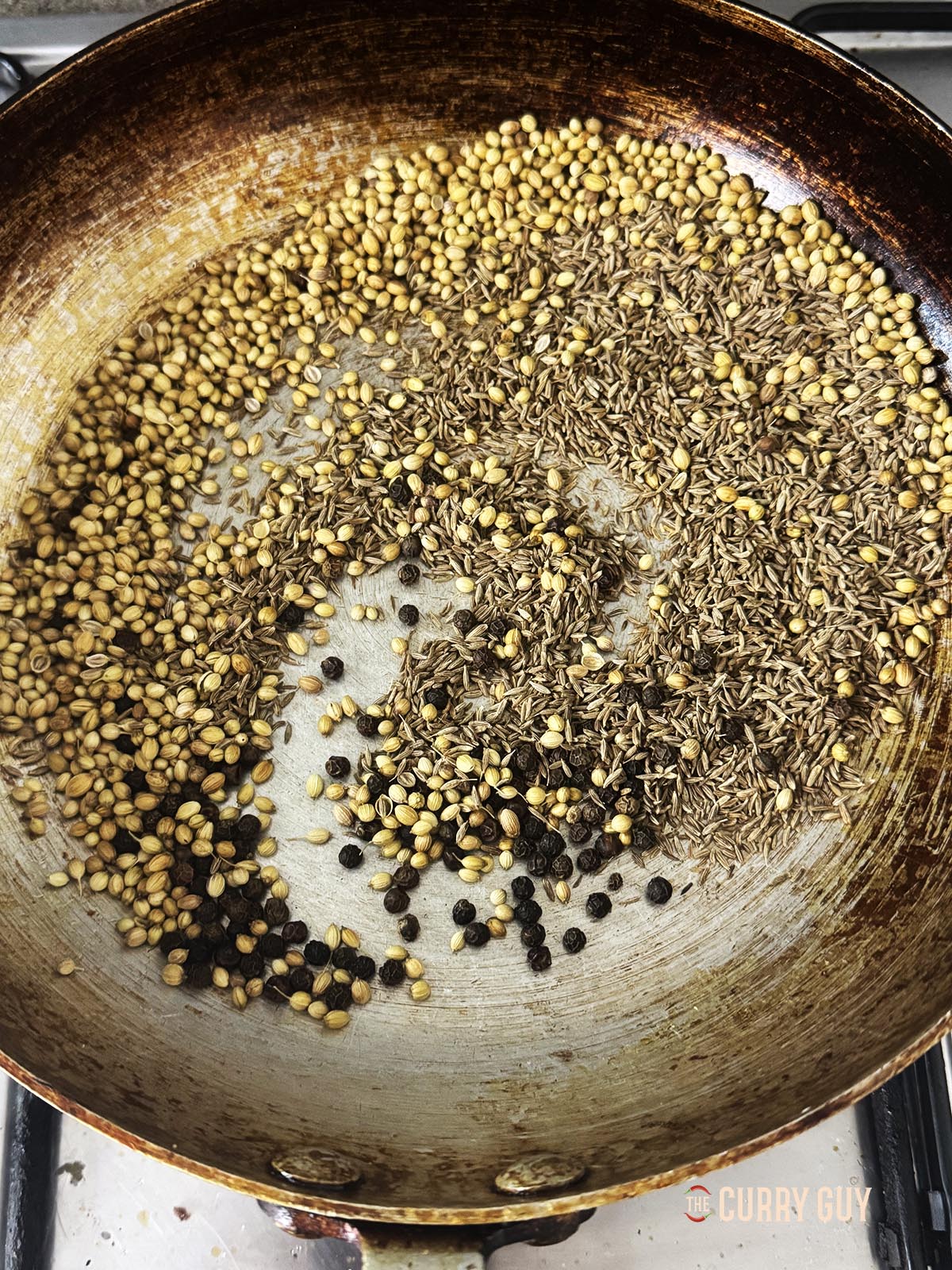 Roasting the whole spices in a pan. 