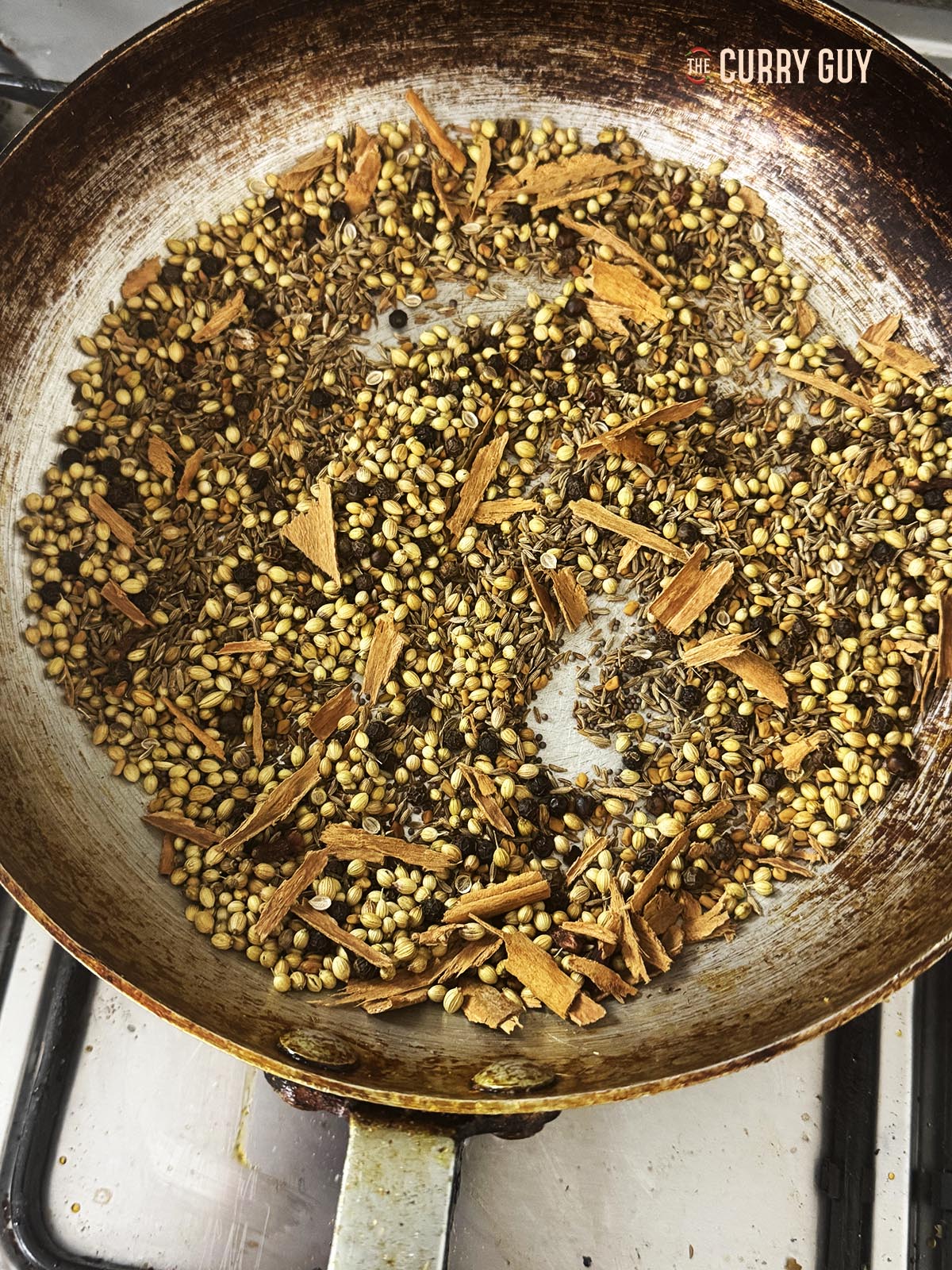 Roasting the spices in a pan.