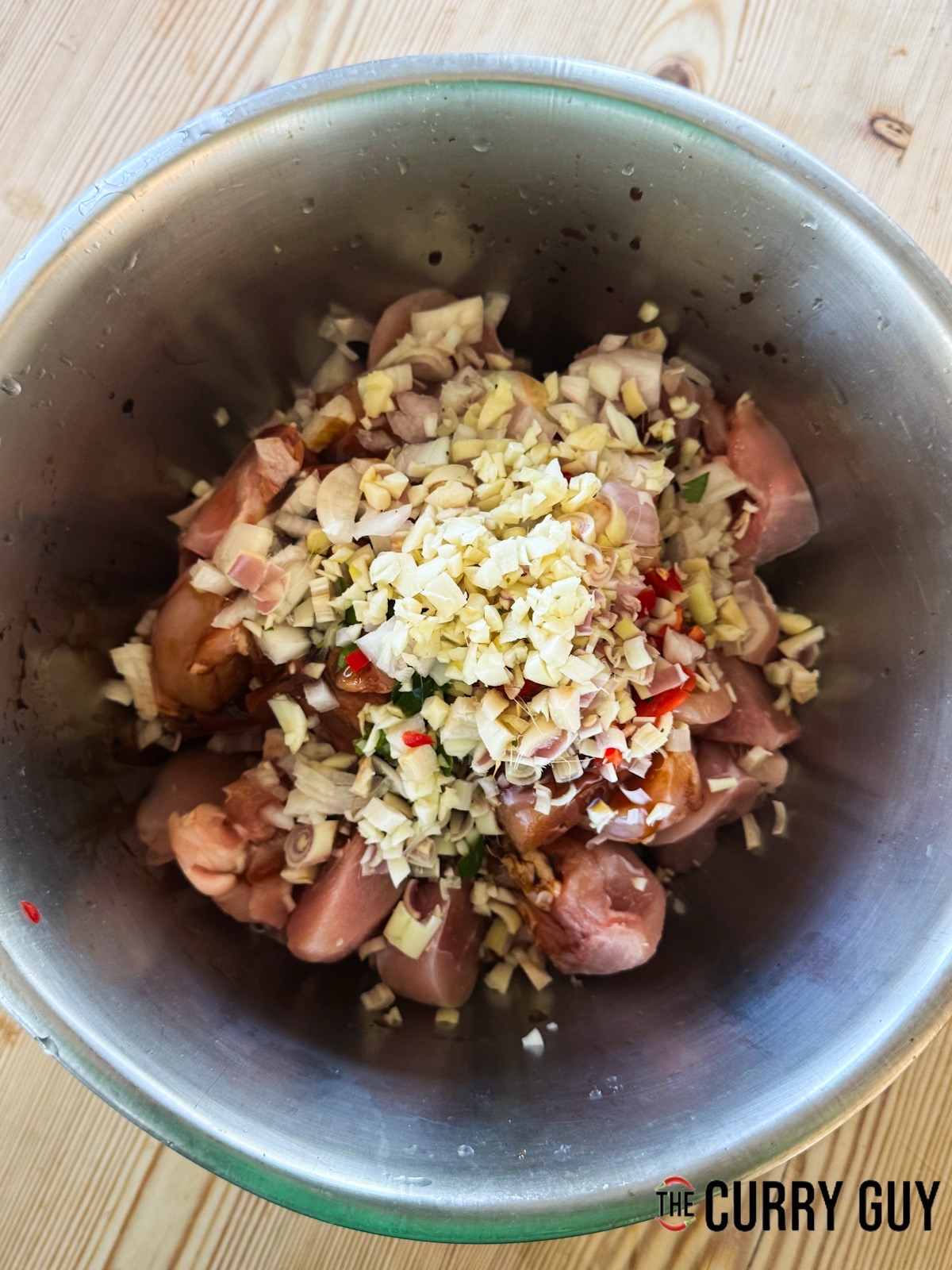 All of the marinade ingredients in a mixing bowl with the chicken.