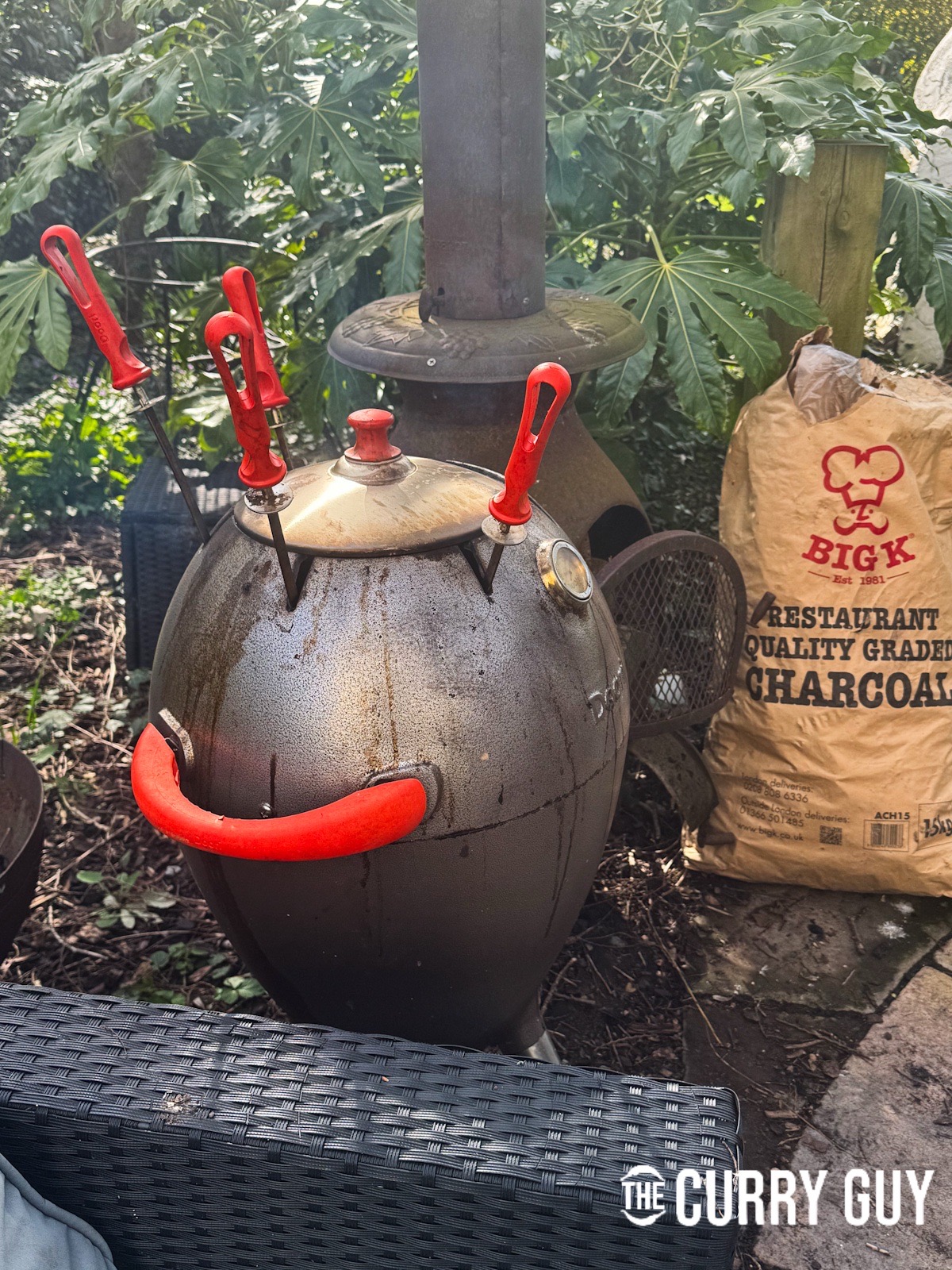 Placing the skewers in the hot tandoor oven.