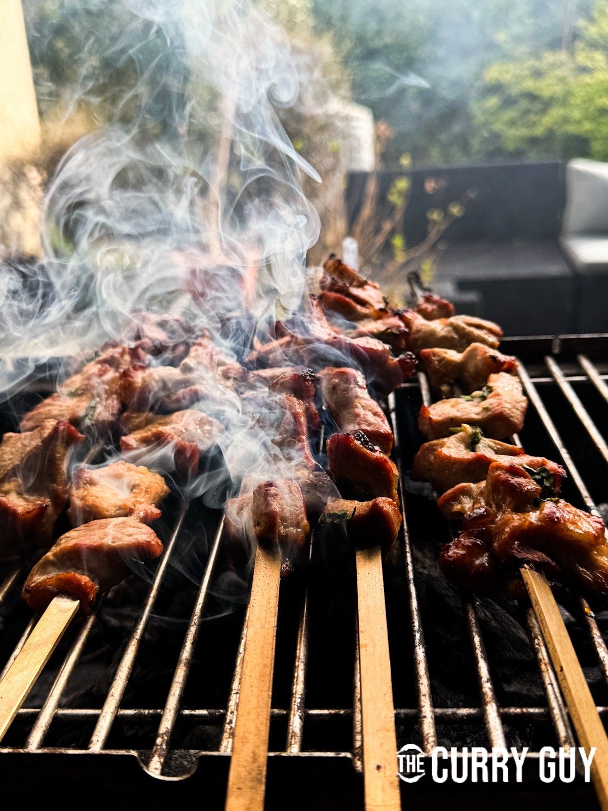Turning the pork skewers on the barbecue.