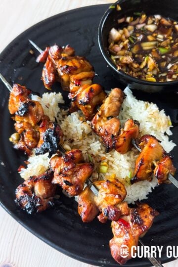 Thai lemon grass chicken skewers over sticky rice and served with nam jim jaew.