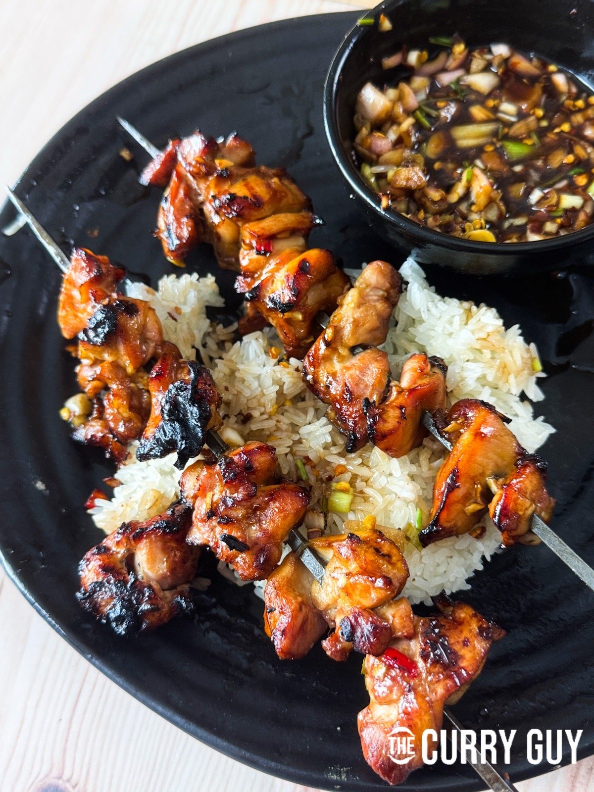 Thai lemon grass chicken skewers over sticky rice and served with nam jim jaew.