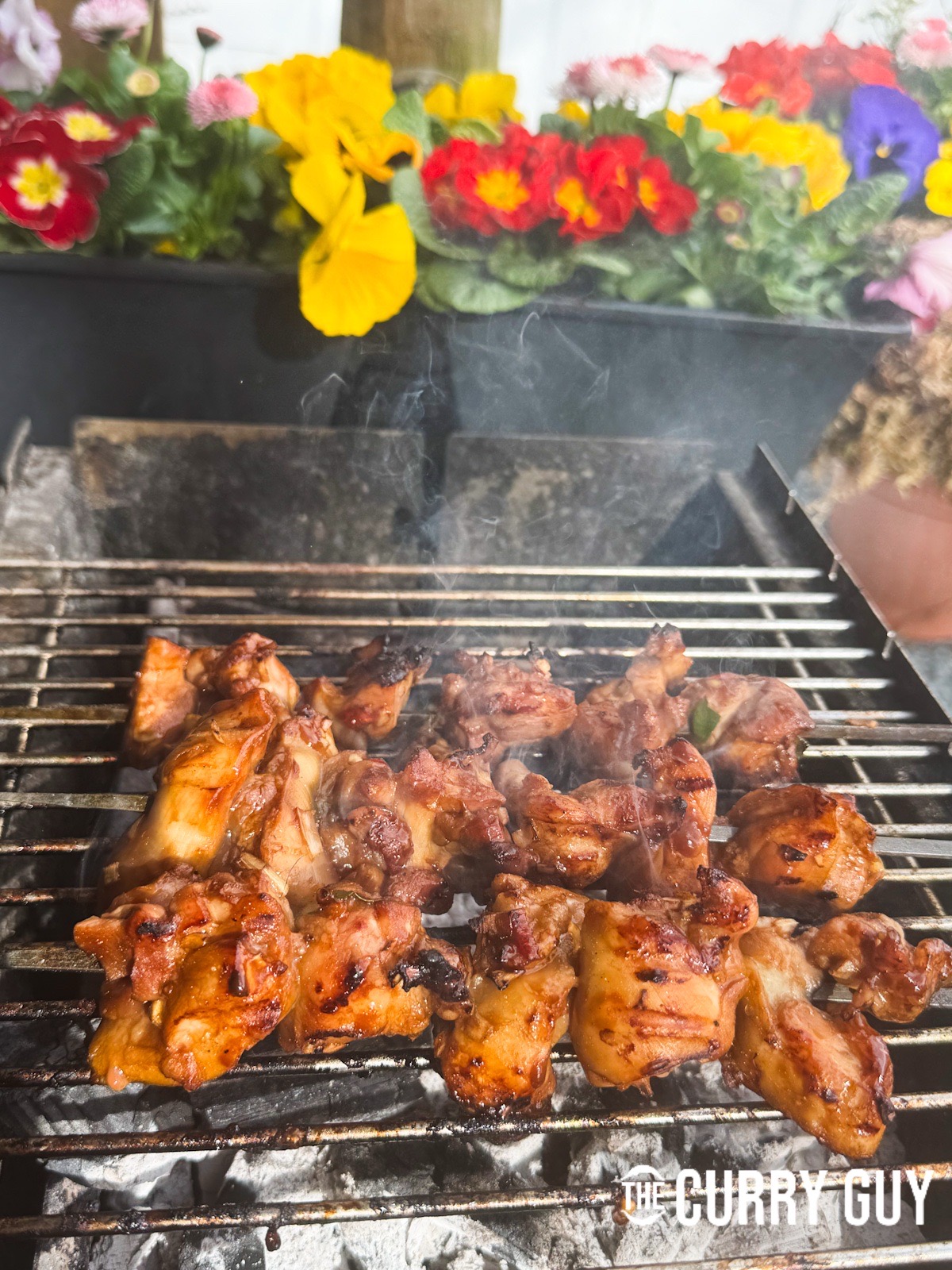 Cooking the chicken skewers on a barbecue as an alternative to the tandoor oven.