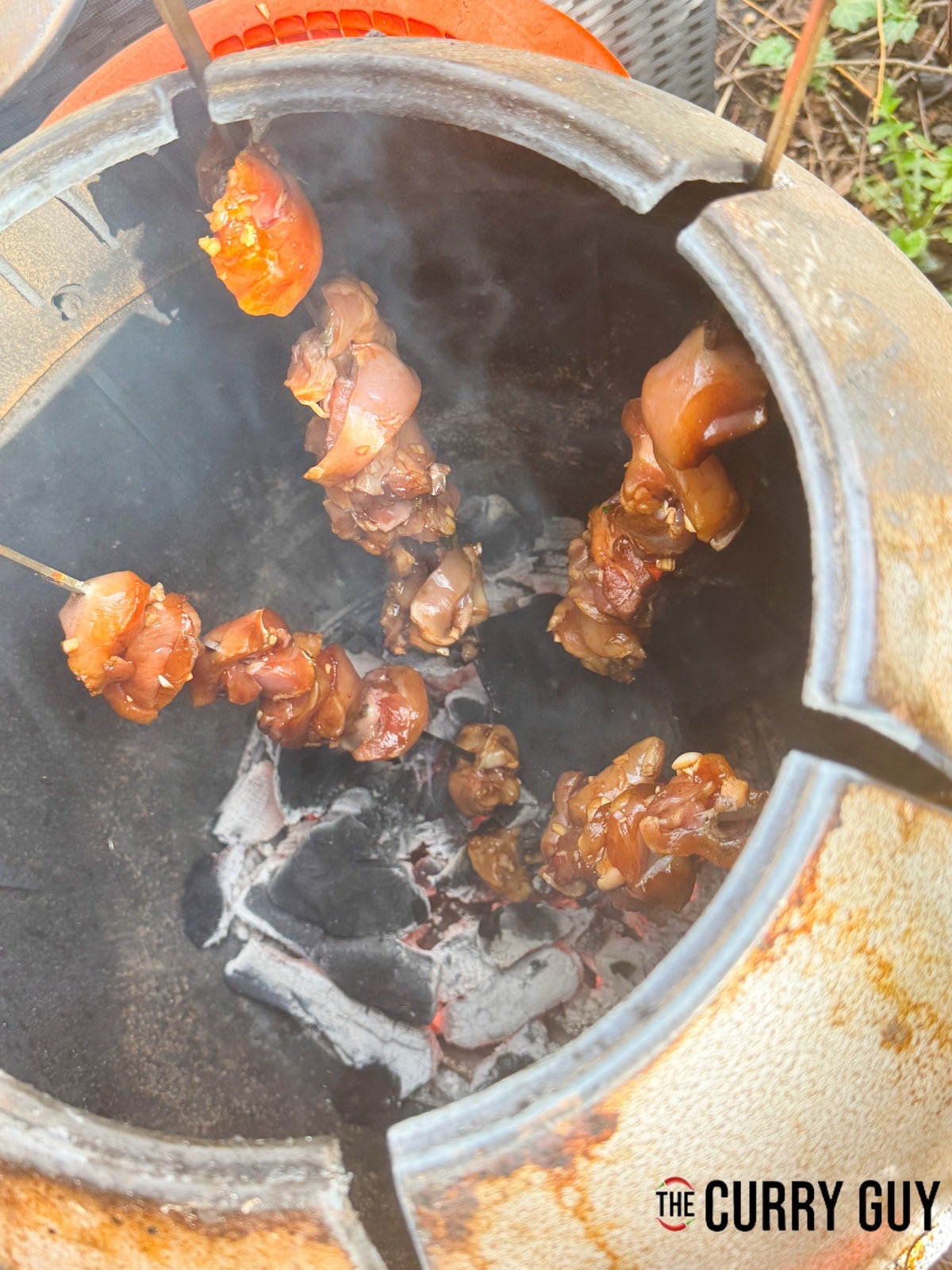 Cooking the chicken skewers in a tandoor oven.