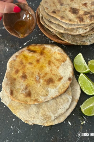 Tandoori rotis on a countertop, drizzled with ghee.