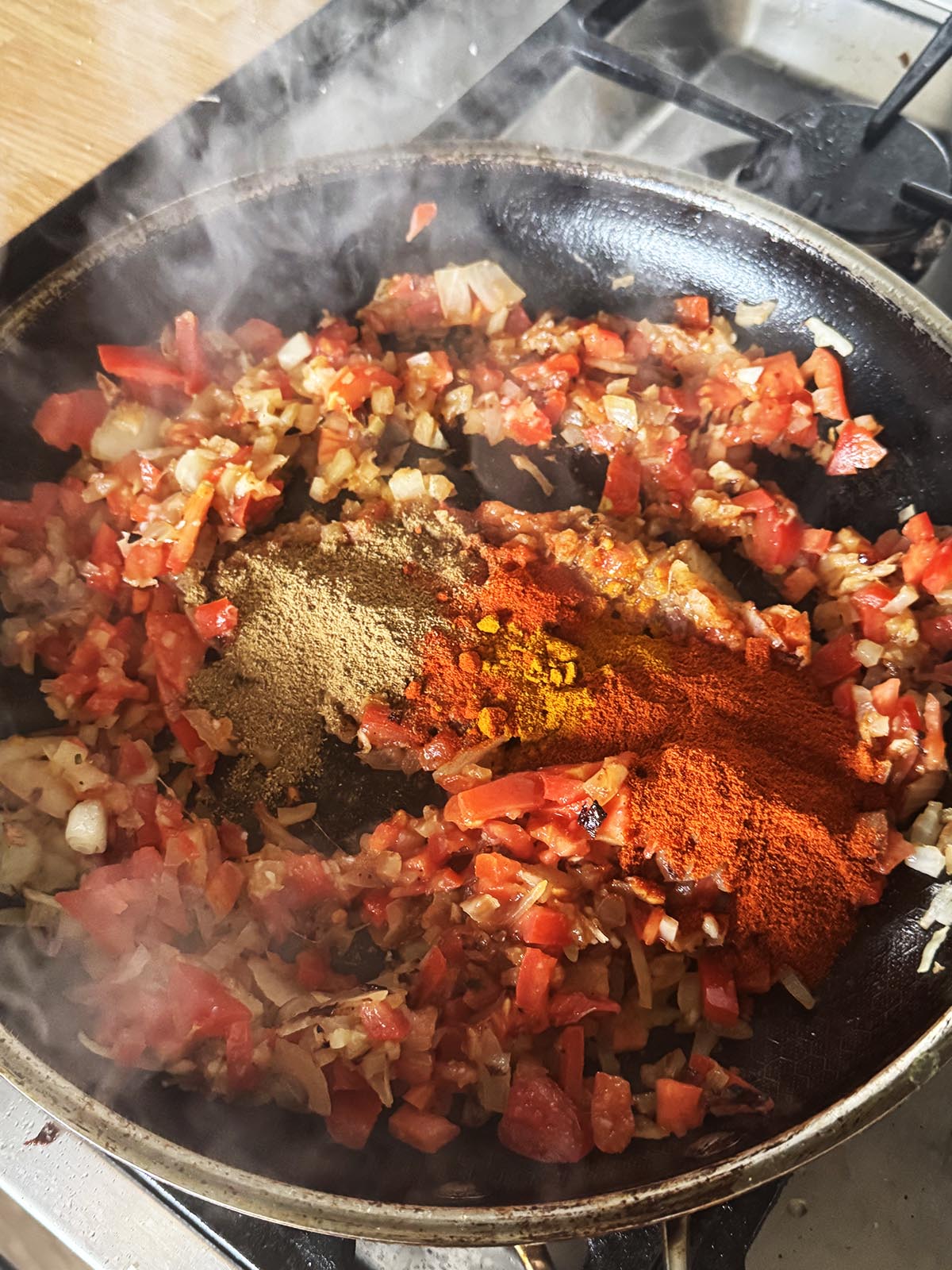 Stirring ground spices into the onion mixture.