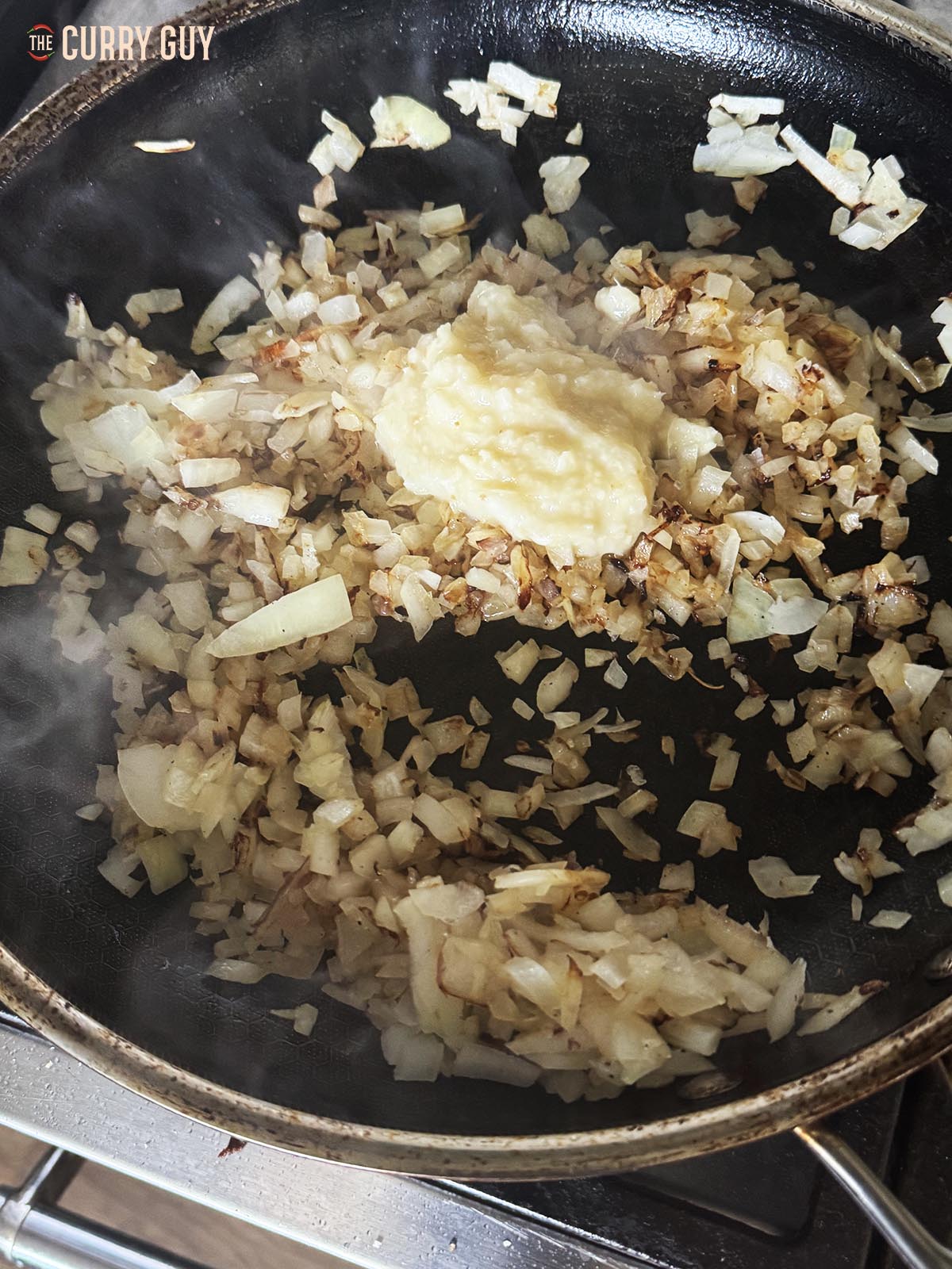 Frying onions and garlic and ginger paste in a pan.