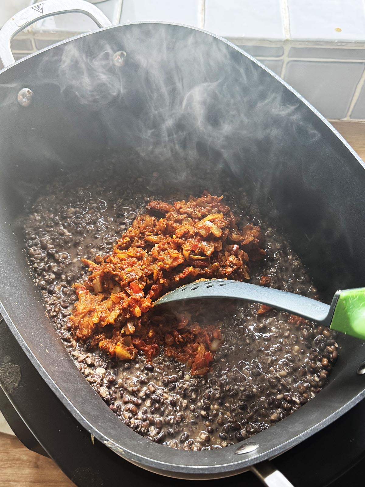 Adding the spice onion mixture to the dal.