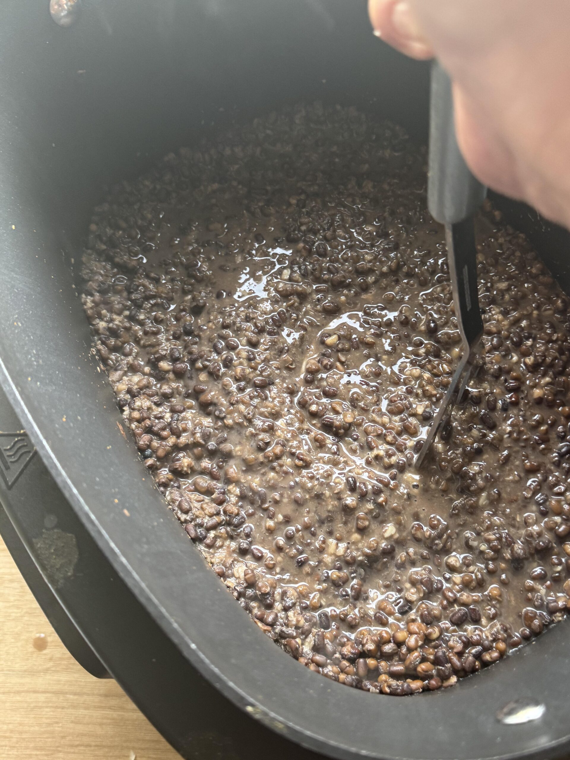 Smashing the cooked dal with a potato masher.