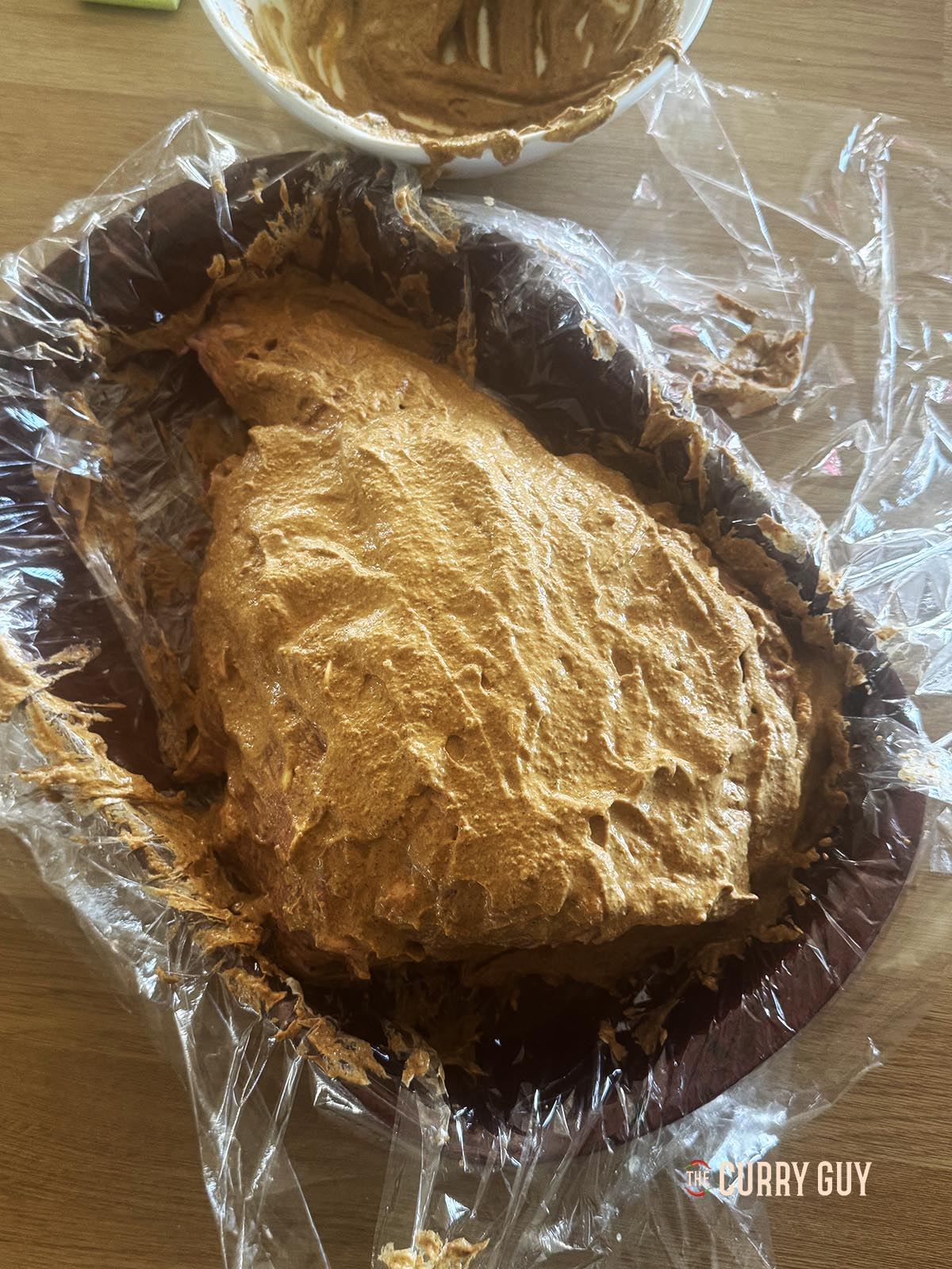 The leg of lamb covered with the marinade before wrapping. 