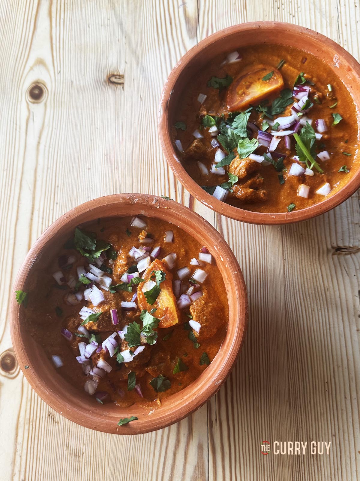 Slow cooker rogan josh served in two serving dishes.