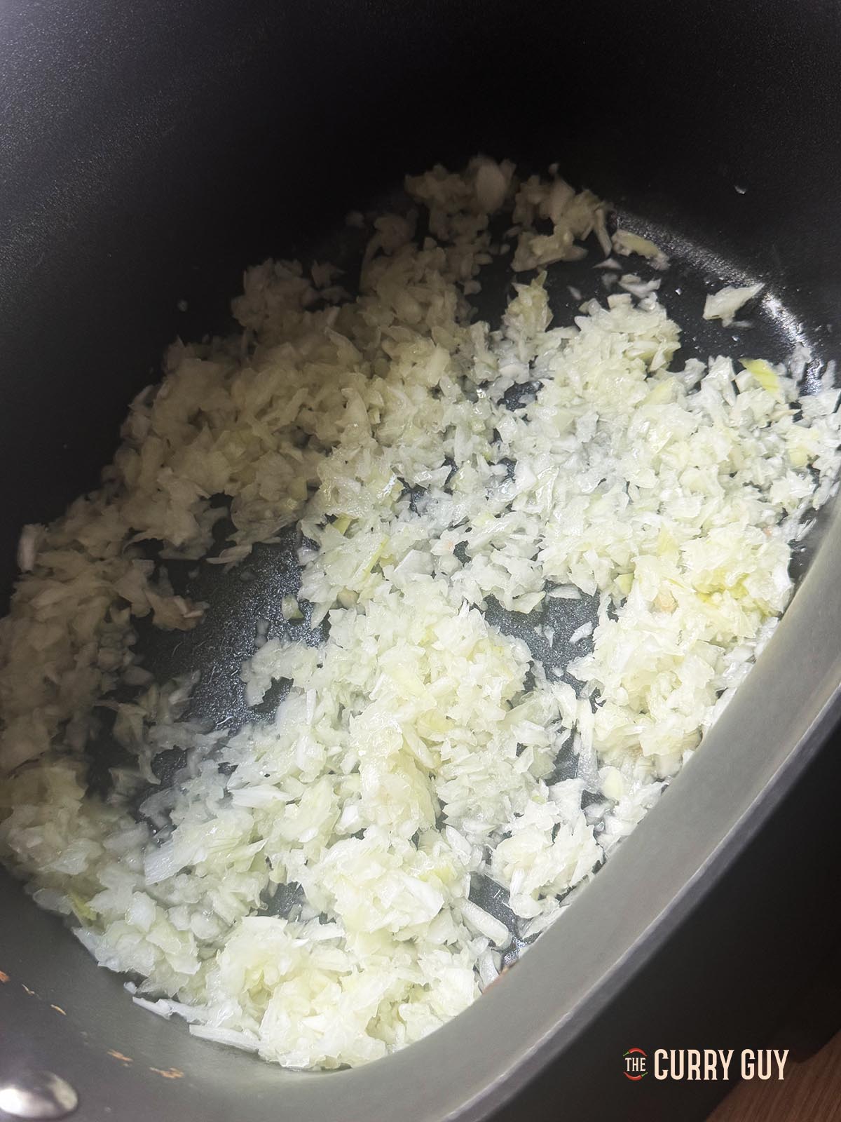 Chopped onions frying in the slow cooker on sauté mode.