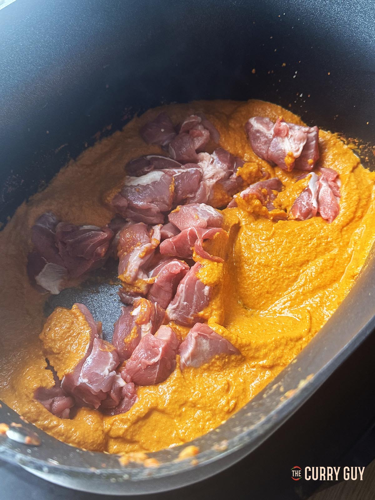 Adding the sauce and meat to the slow cooker to cook.