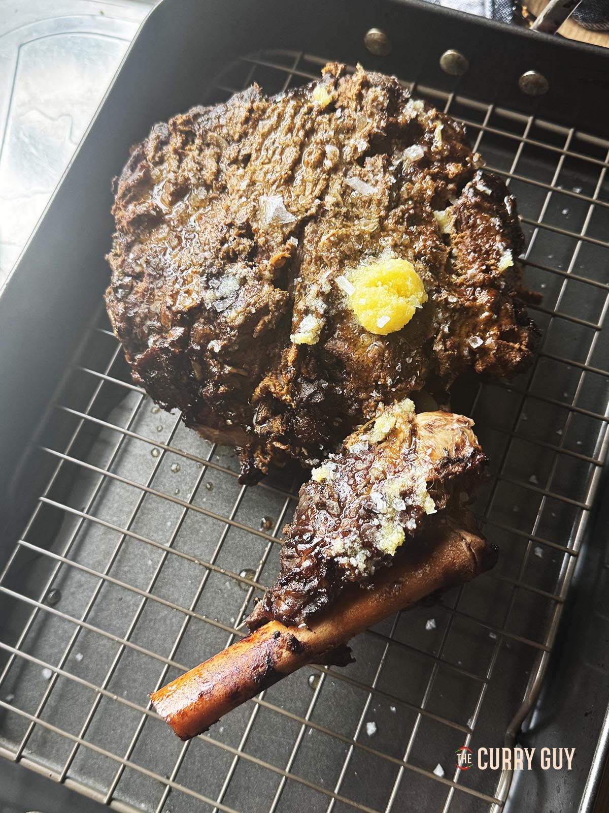 The slowly cooked lamb on a rack ready to place in the oven to char the exterior.