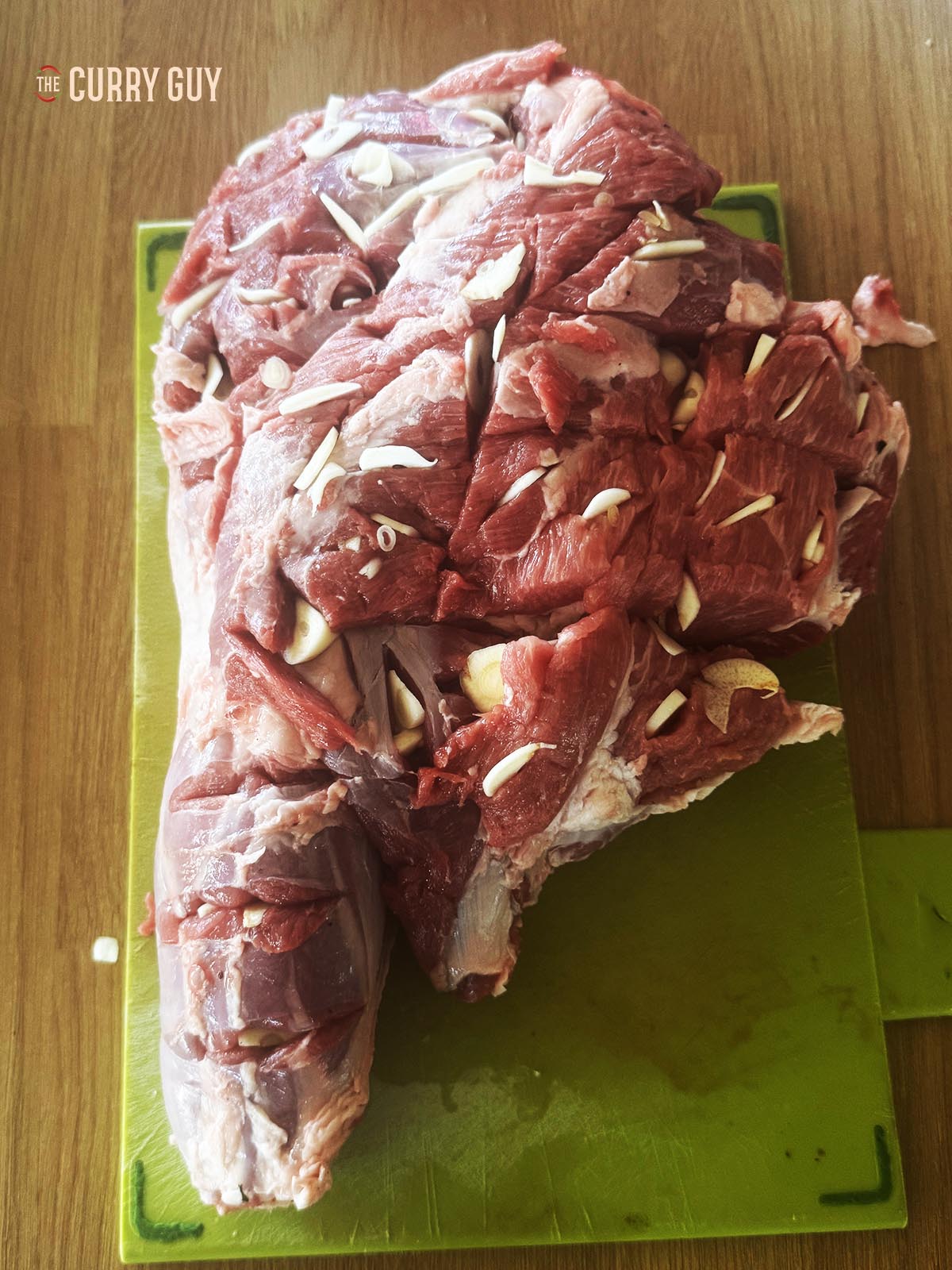 The lamb leg scored and with garlic slivers in slits, ready for the marinade.