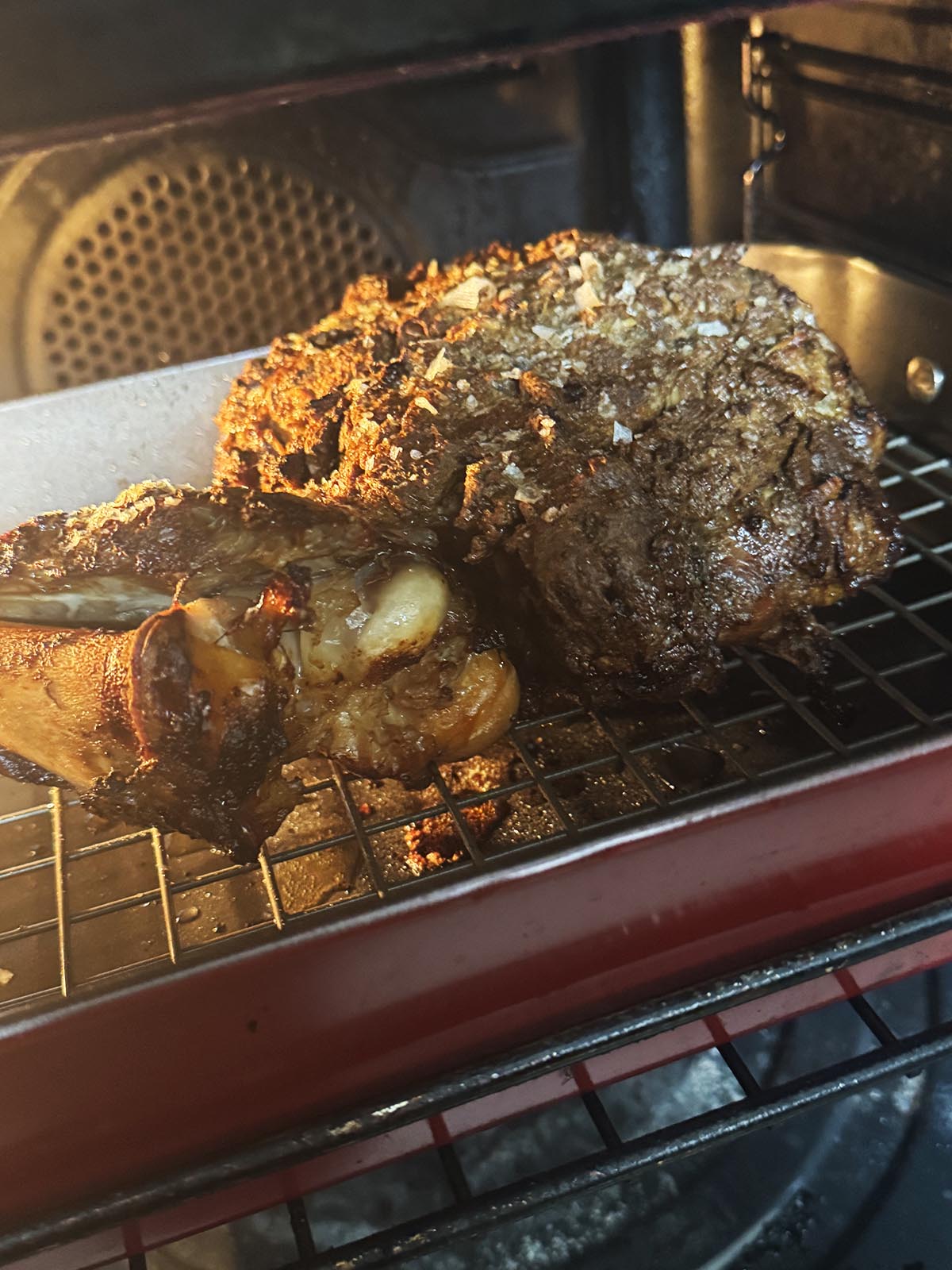 Roasting the lamb on high in the oven to char the exterior.