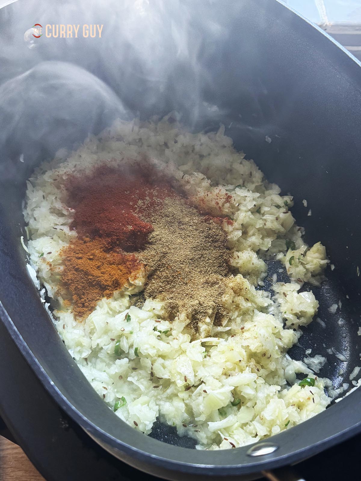 Adding the ground spices into the onion mixture.