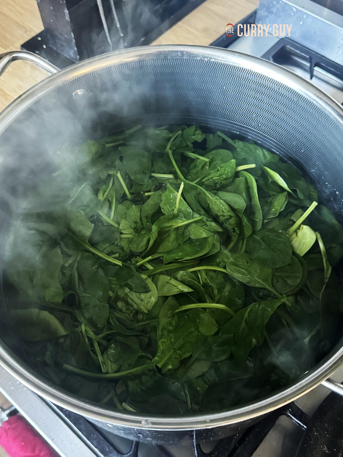 Blanching fresh spinach in a large pot of boiling water