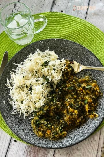 The slow cooker saag served on a plate with white rice.