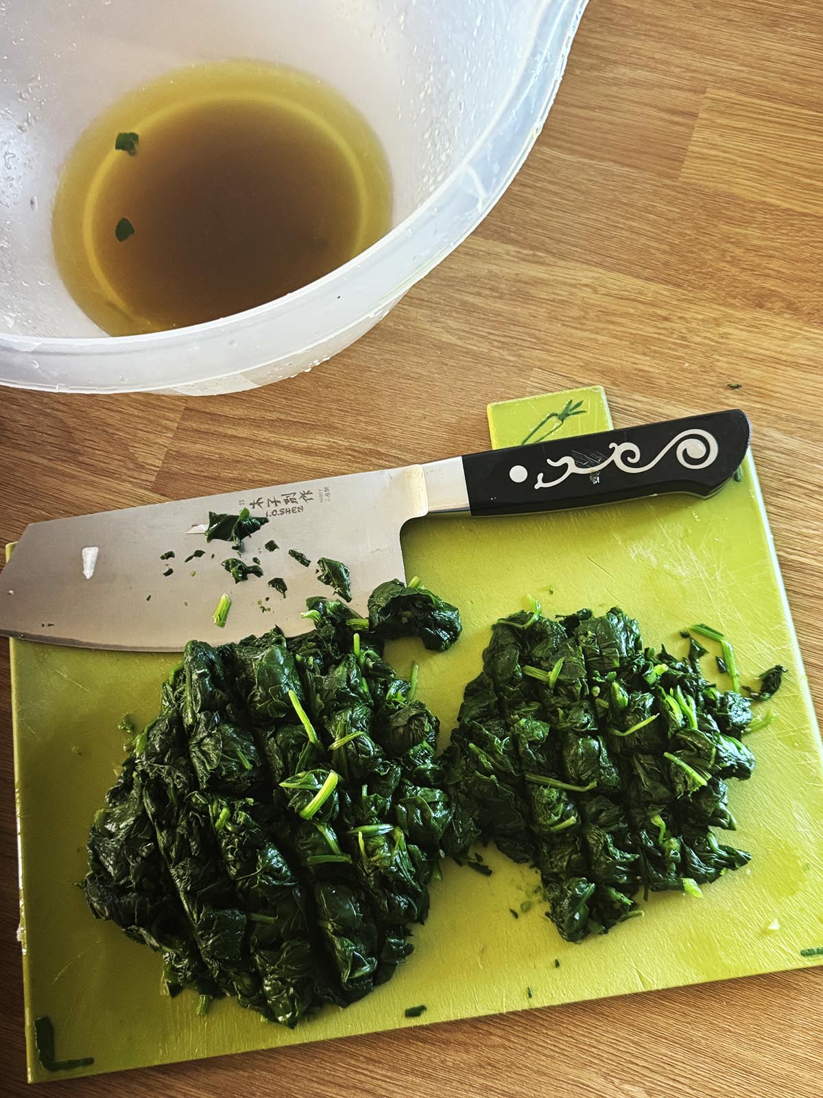 Blanched spinach on a cutting board, roughly chopped