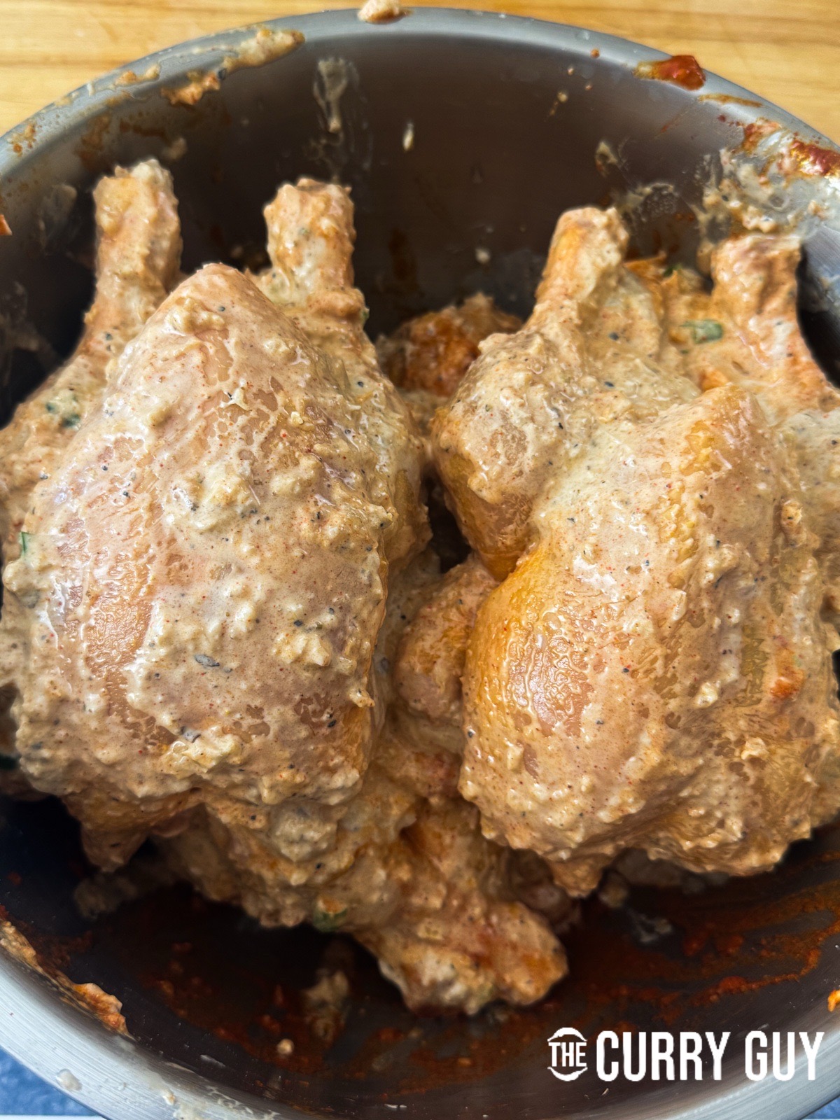The chicken marinating in both marinades in a bowl.