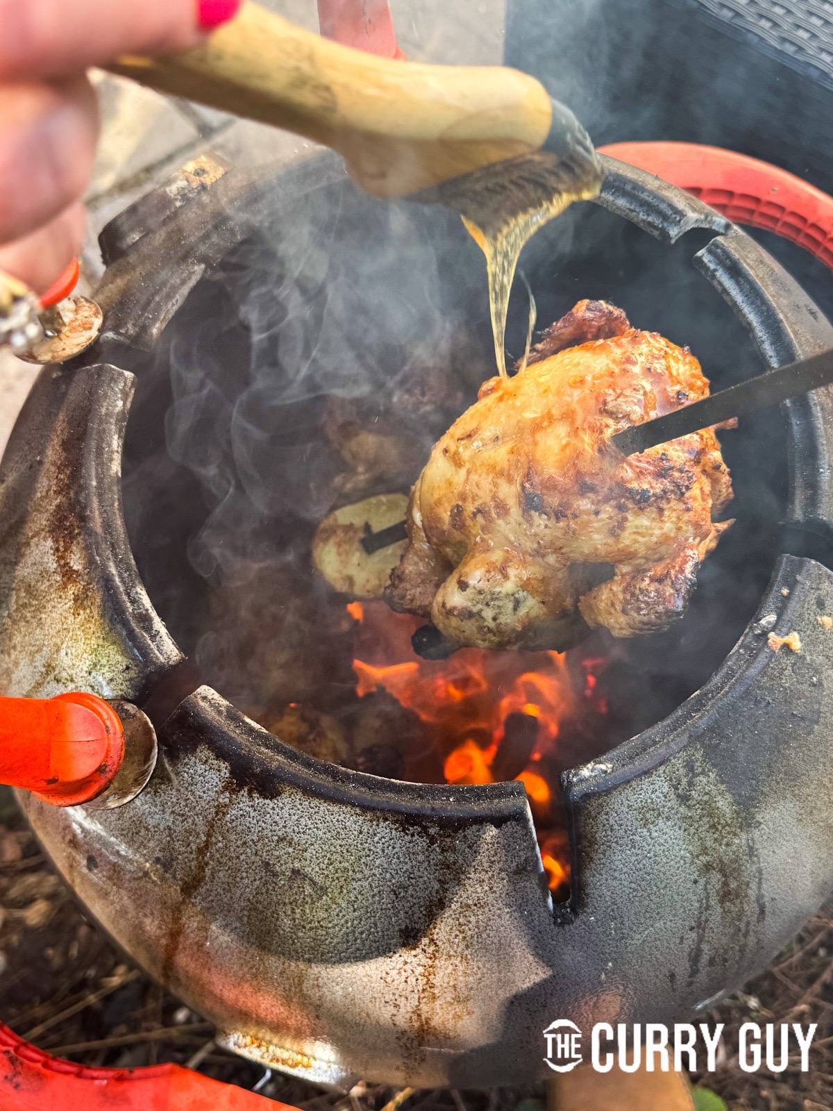 Basting a chicken with the ghee and honey mixture.