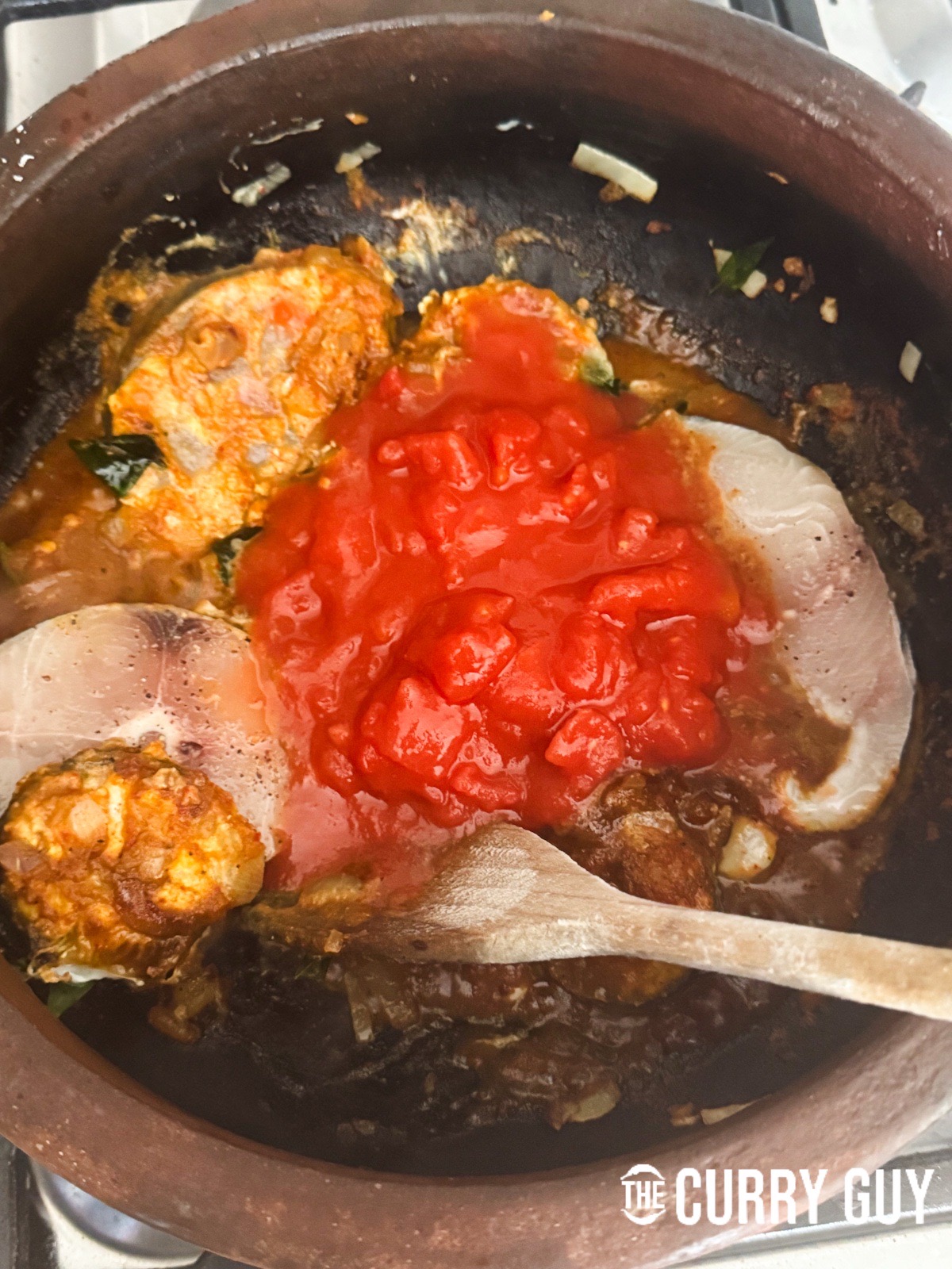 Adding the chopped tomatoes to the pot.