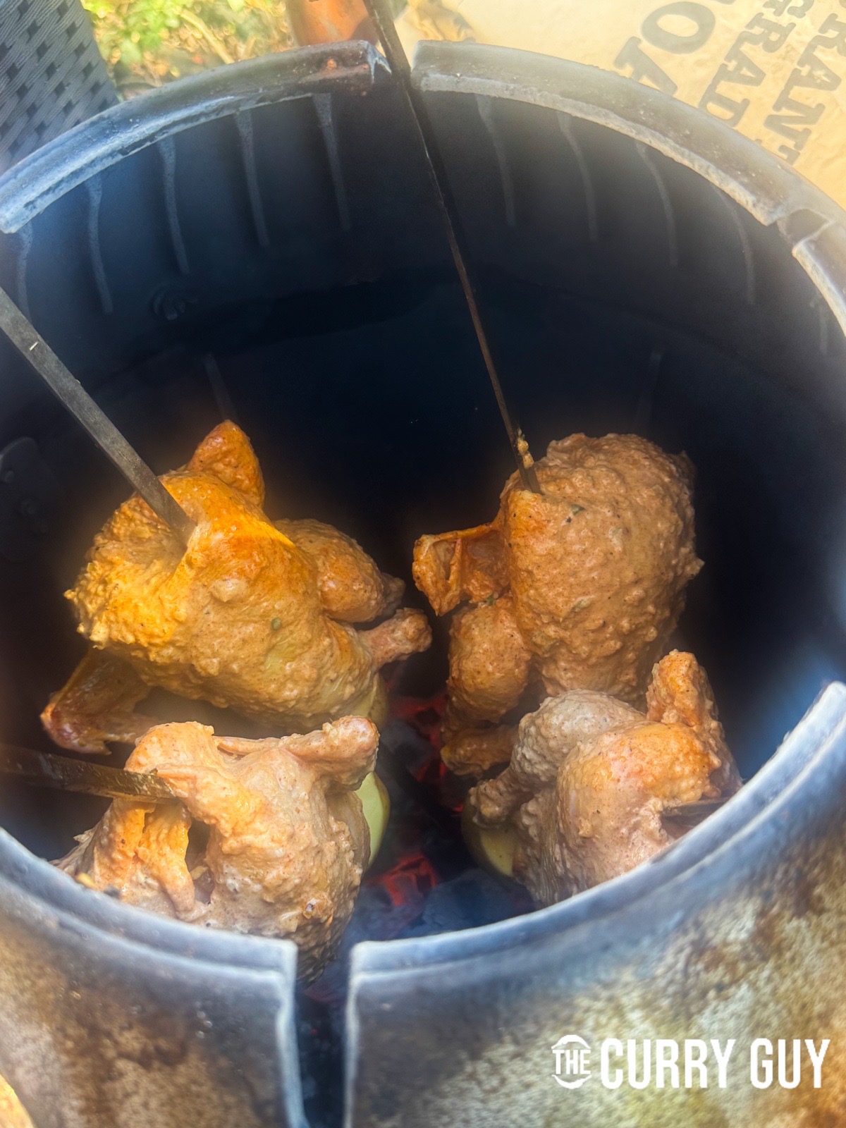 Placing the skewered chicken in the tandoori oven.