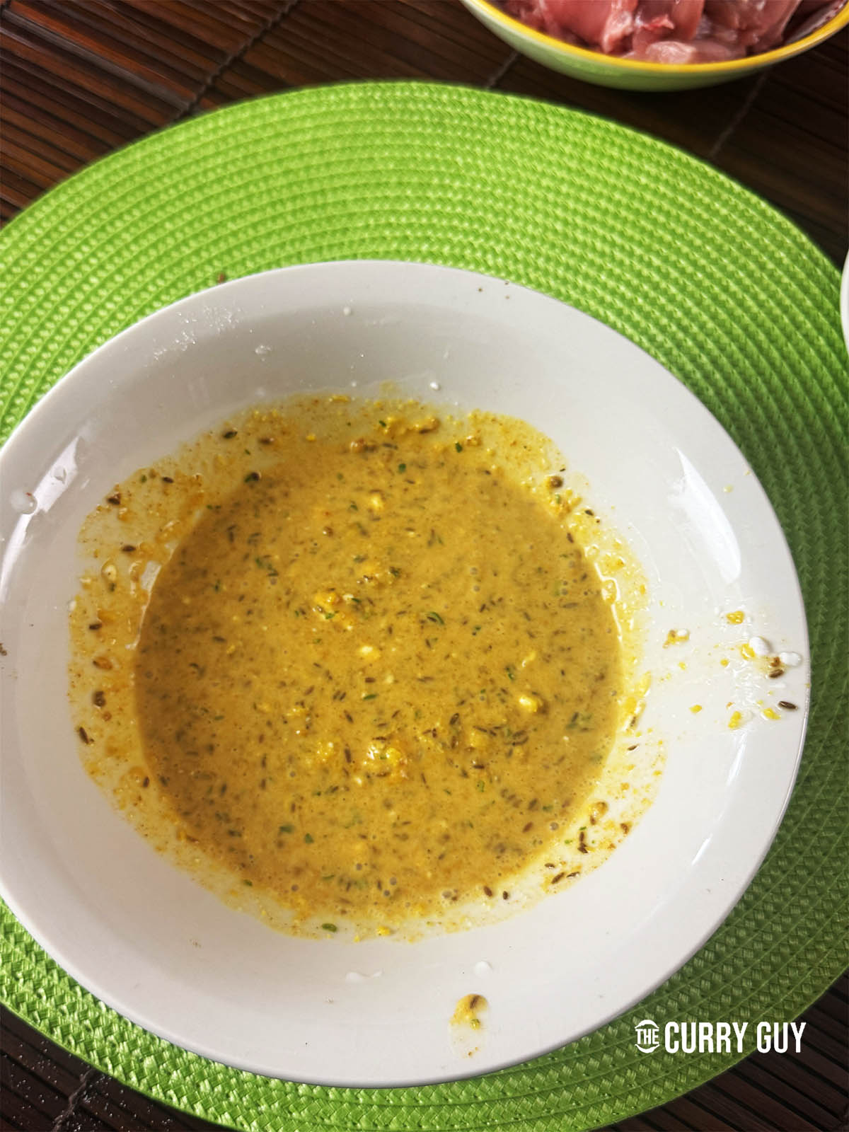 Adding the paste to the coconut milk and stirring it with the cinnamon, sugar, vinegar and salt.