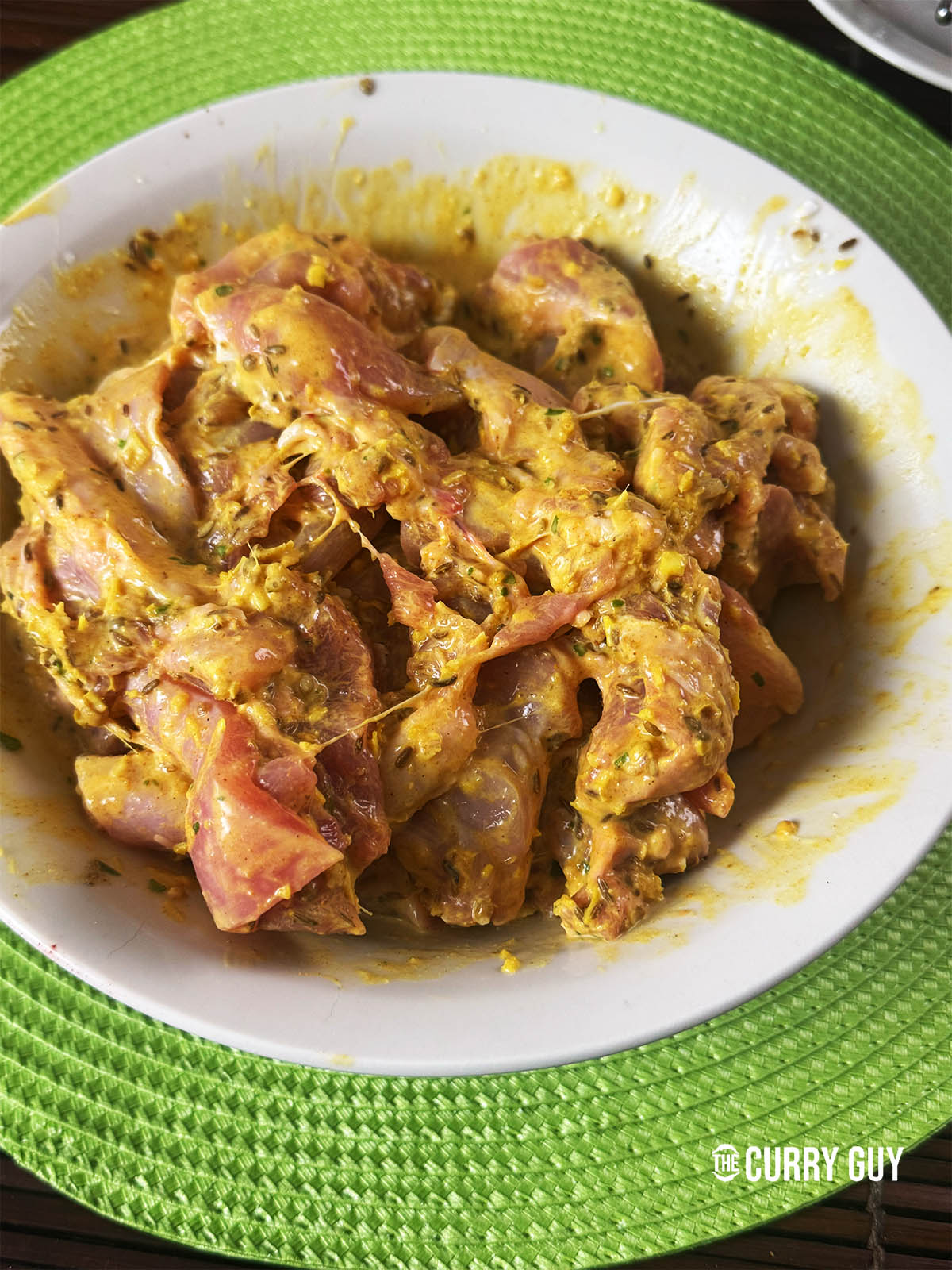 Adding the chicken to the marinade.