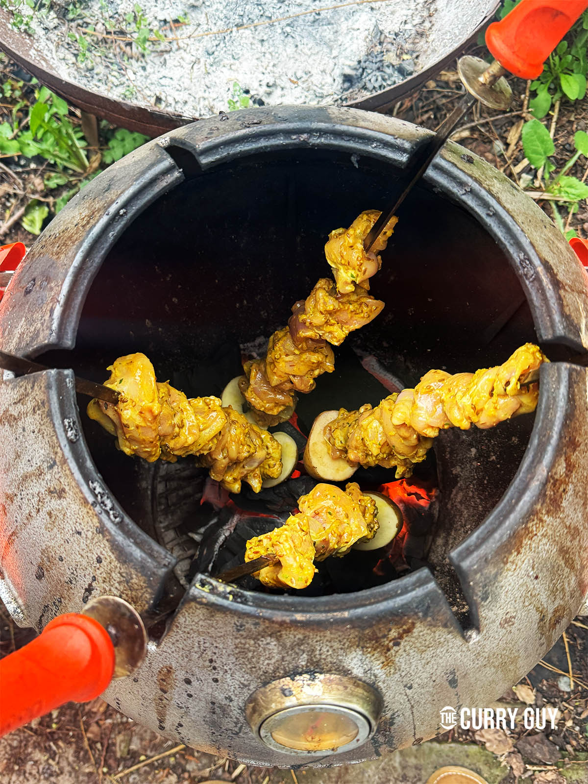 Placing the skewers in a tandoor oven