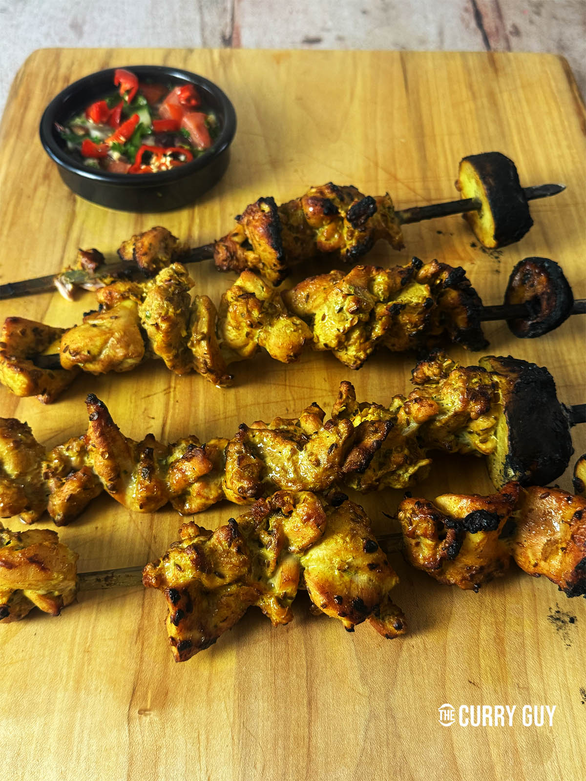 The cooked Thai chicken satay on a serving board.
