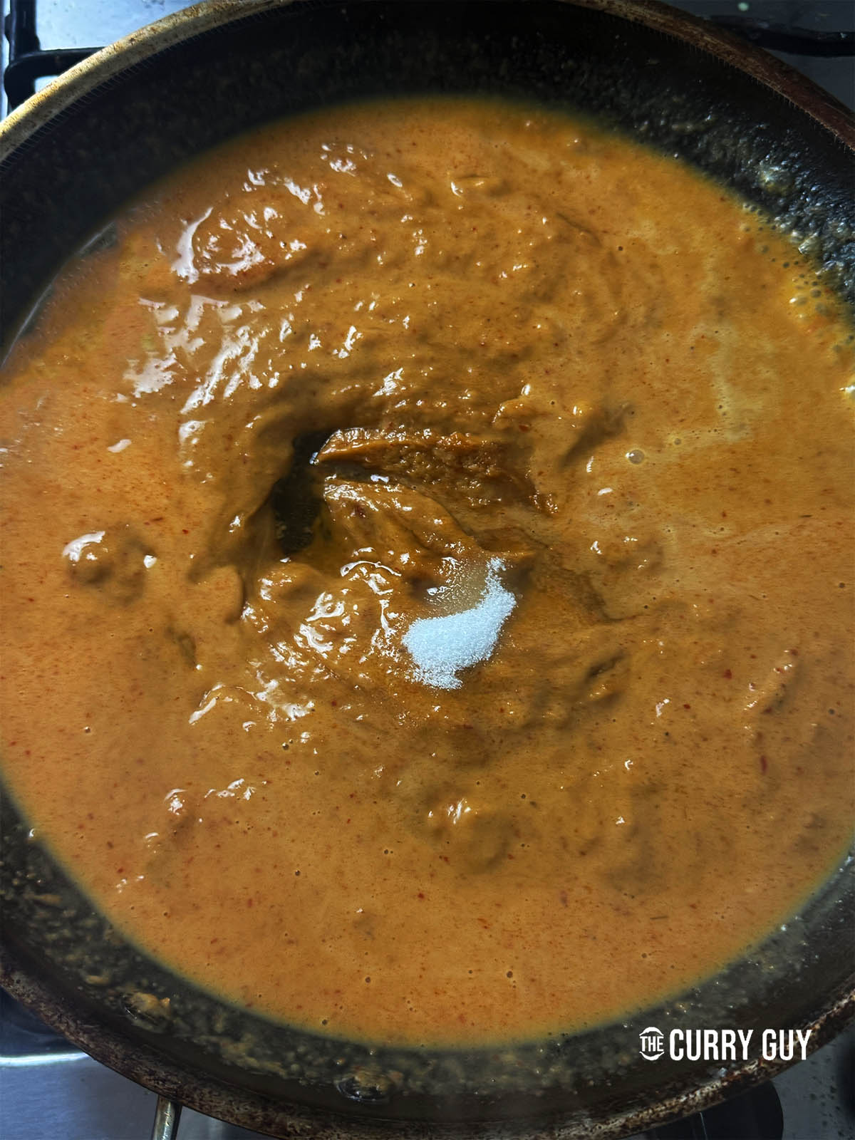 Stirring sugar into the sauce.